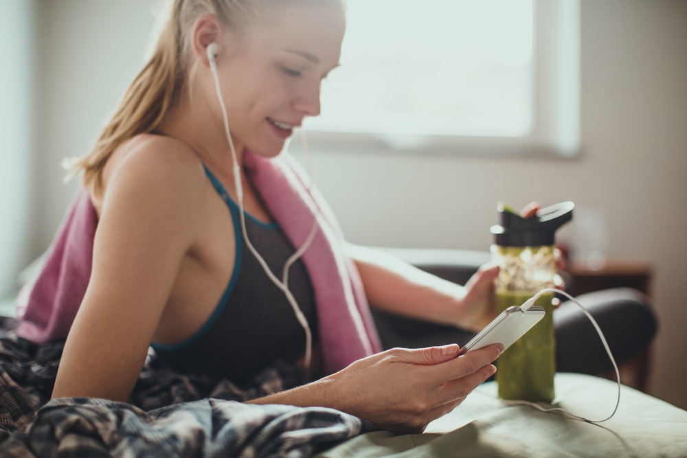 woman with headphones and smoothie while resting