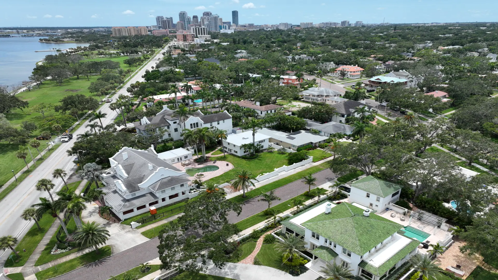 Aerial drone photo of the Historic Old Northeast neighborhood in St. Petersburg, showing waterfront homes along North Shore Drive, tree-lined streets, and downtown St. Petersburg in the background.