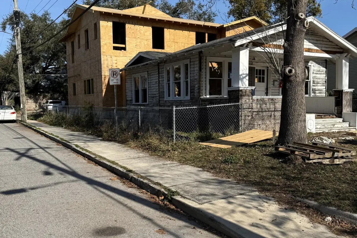 Front street view of the Hyde Park home renovation showing the original bungalow and new two-story addition under construction.