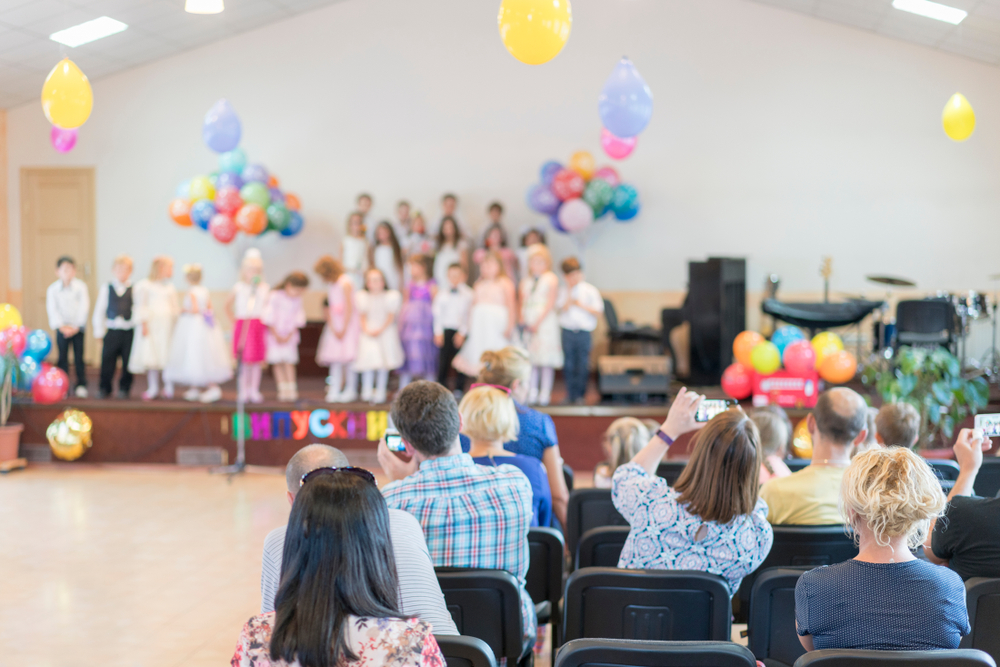 Parents watching a children's school performance