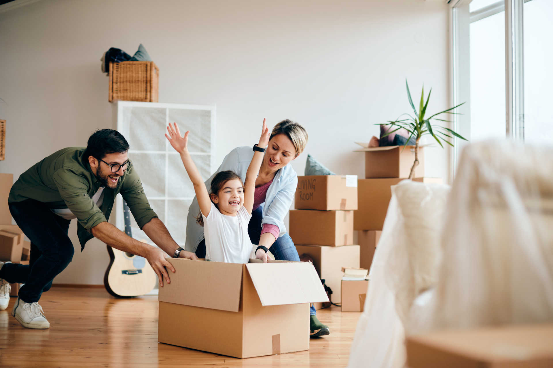A happy family carrying boxes into their new home, excitedly starting a new chapter in their lives