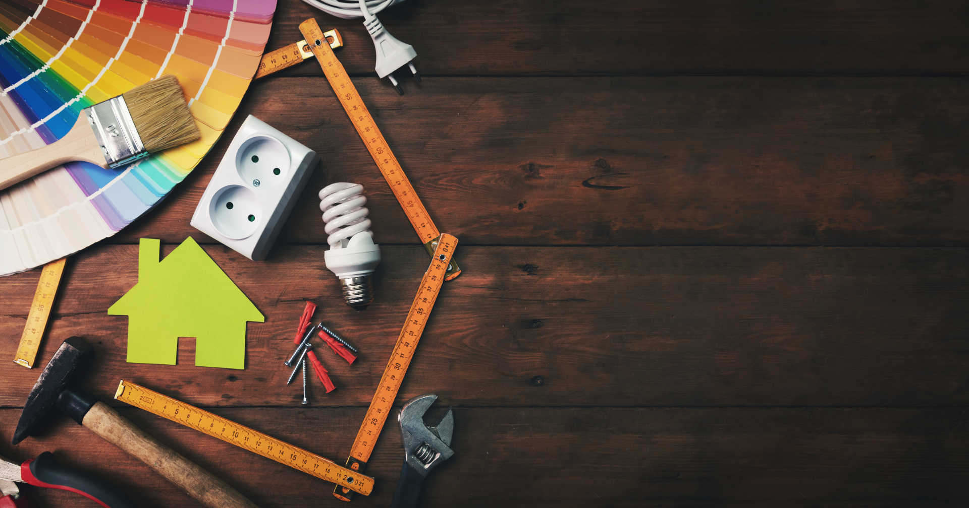 Various tools and paint colors neatly arranged on a wooden table.