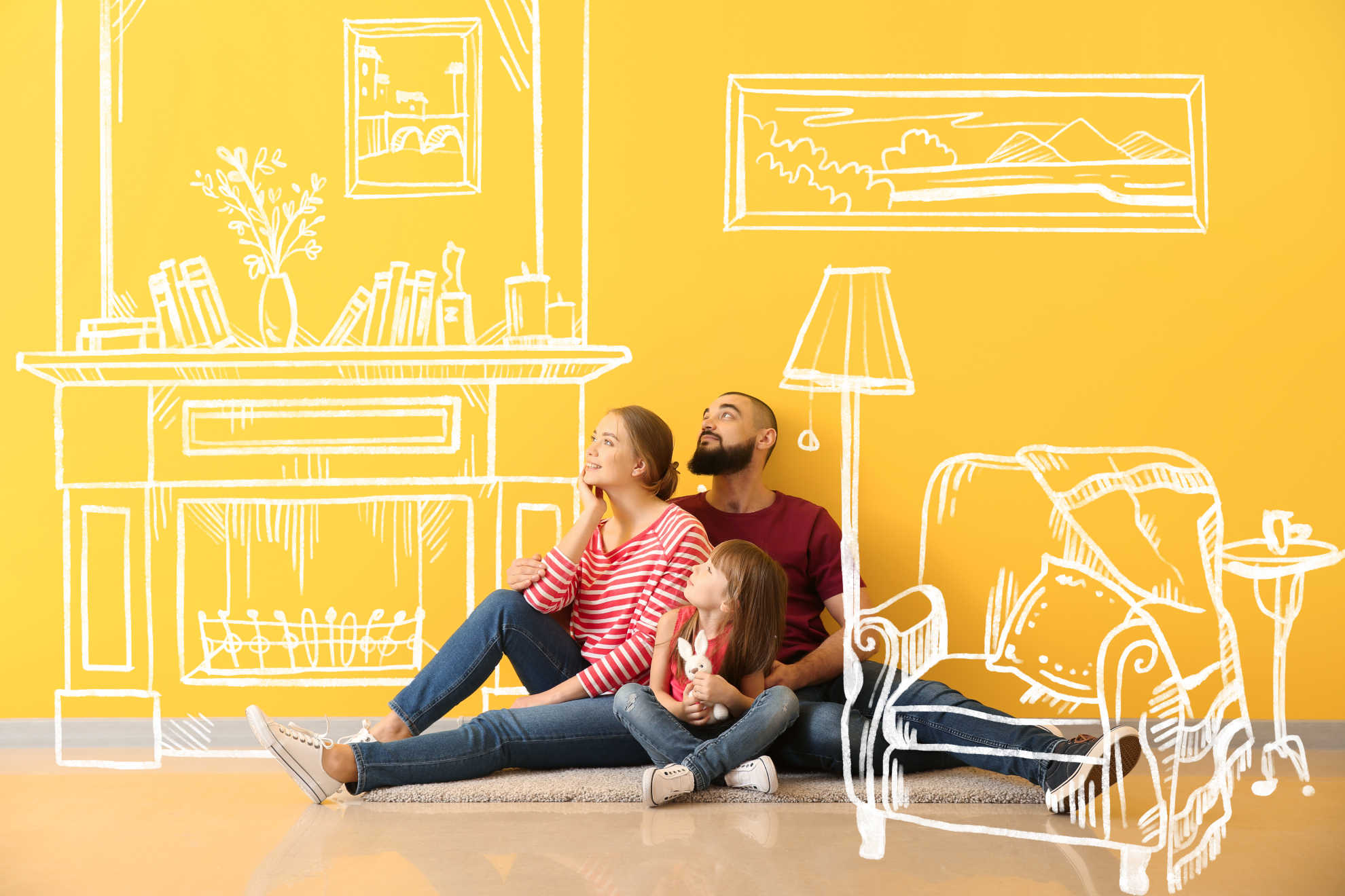 A happy family gathered on the floor, smiling together in front of a bright yellow wall, creating a warm atmosphere.