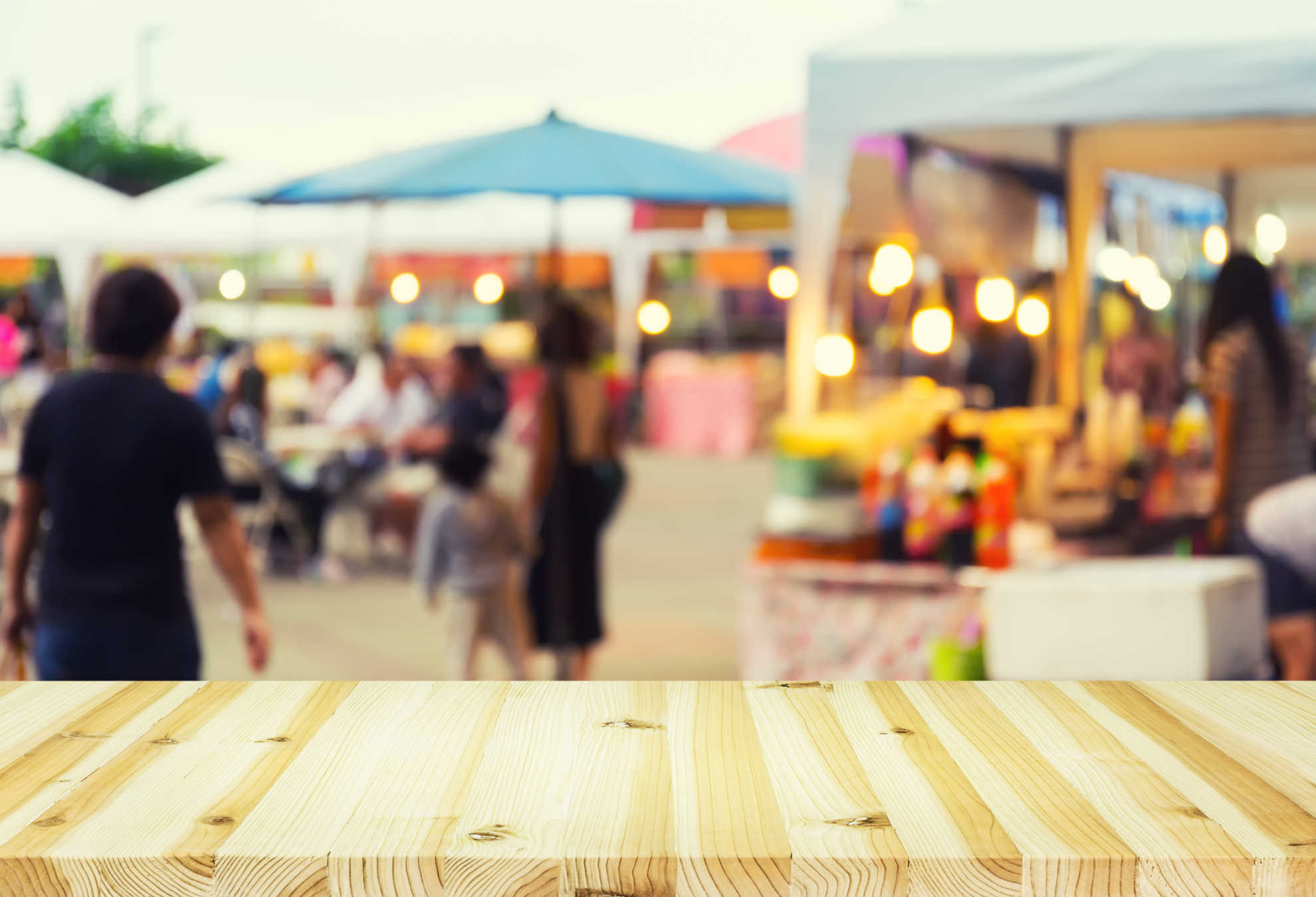A close-up of a wooden table top with a softly blurred background, creating a warm and inviting atmosphere.