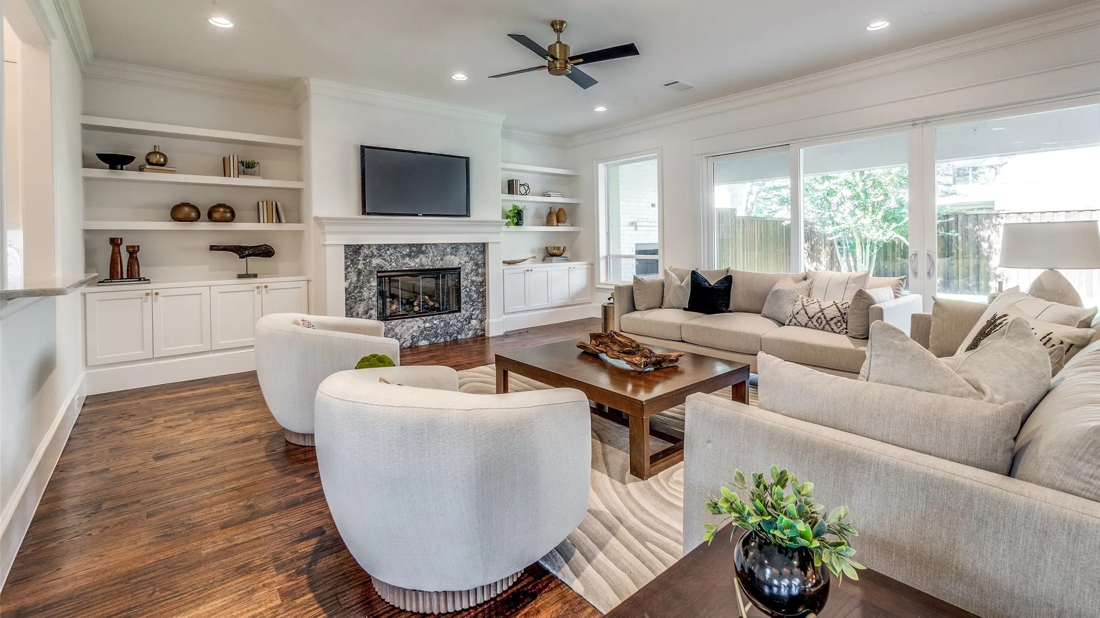 Cozy living room featuring white furniture and a warm fireplace, creating a welcoming and stylish atmosphere.