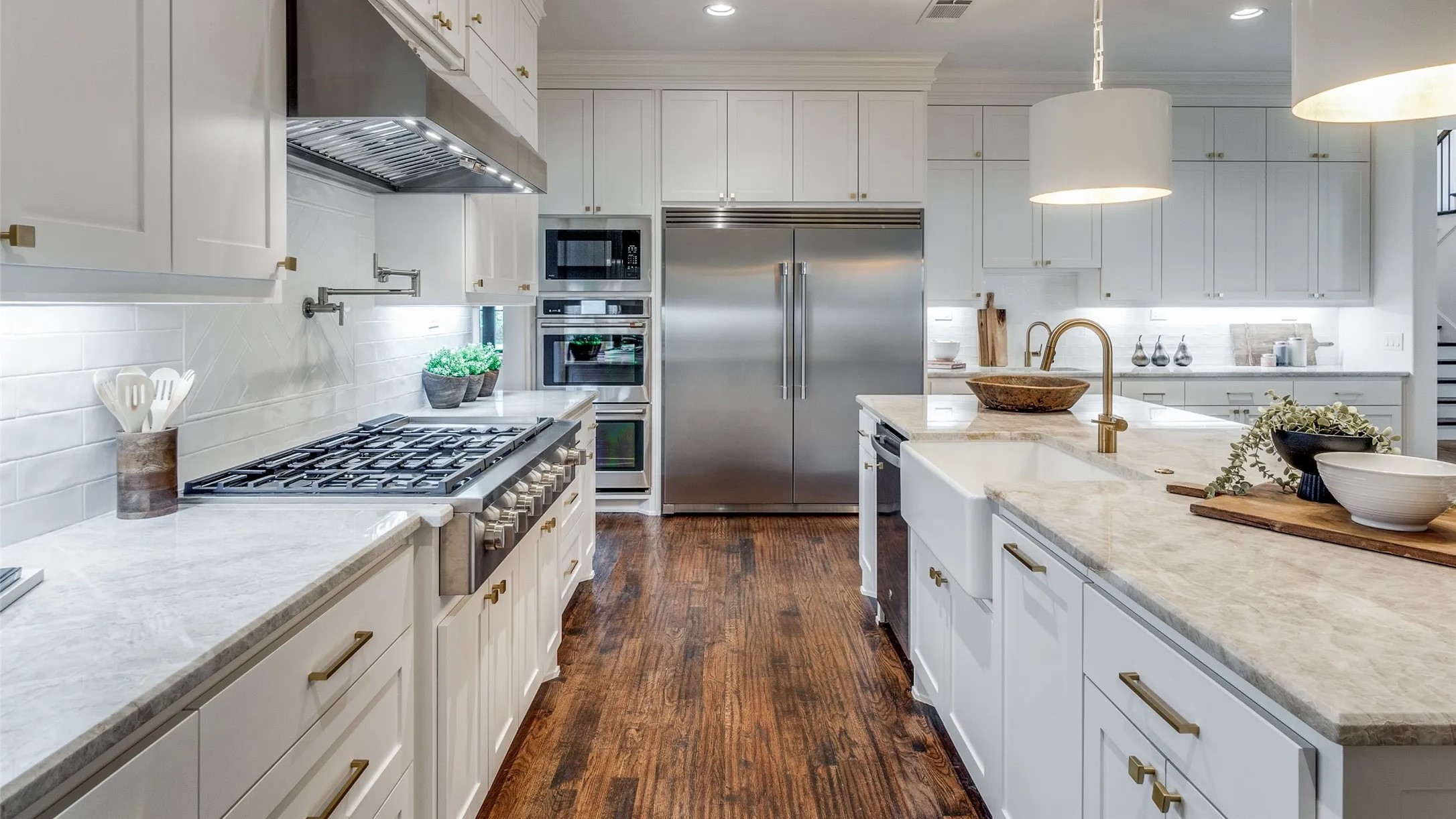 A bright kitchen featuring sleek white cabinets and warm wood floors, creating a clean and inviting atmosphere.