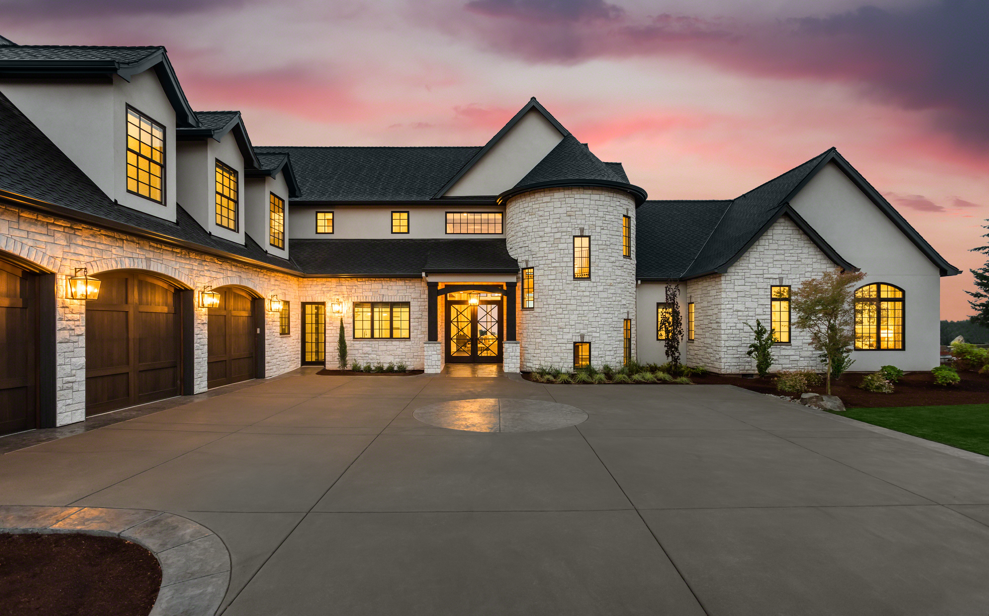 A stunning home featuring a spacious driveway and an attached garage, showcasing elegant architecture and landscaping.