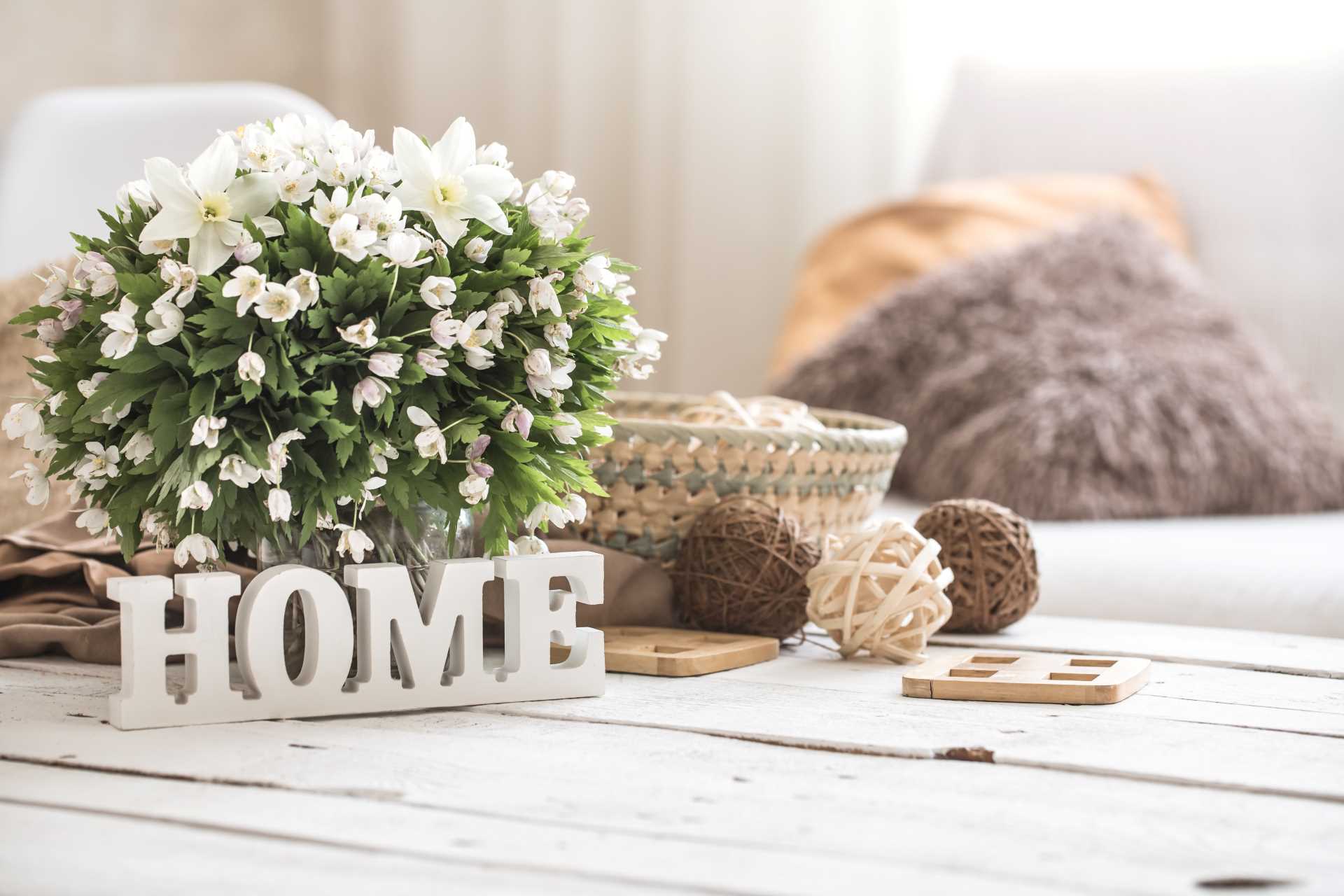 Home decor featuring a floral arrangement and a rustic wooden sign displayed elegantly on a table.