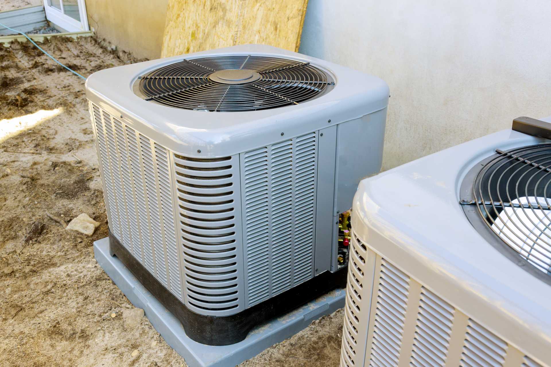 Two outdoor air conditioners in a yard, highlighting the concept: Beat the Heat: Energy-Efficient Upgrades for cooling solutions.