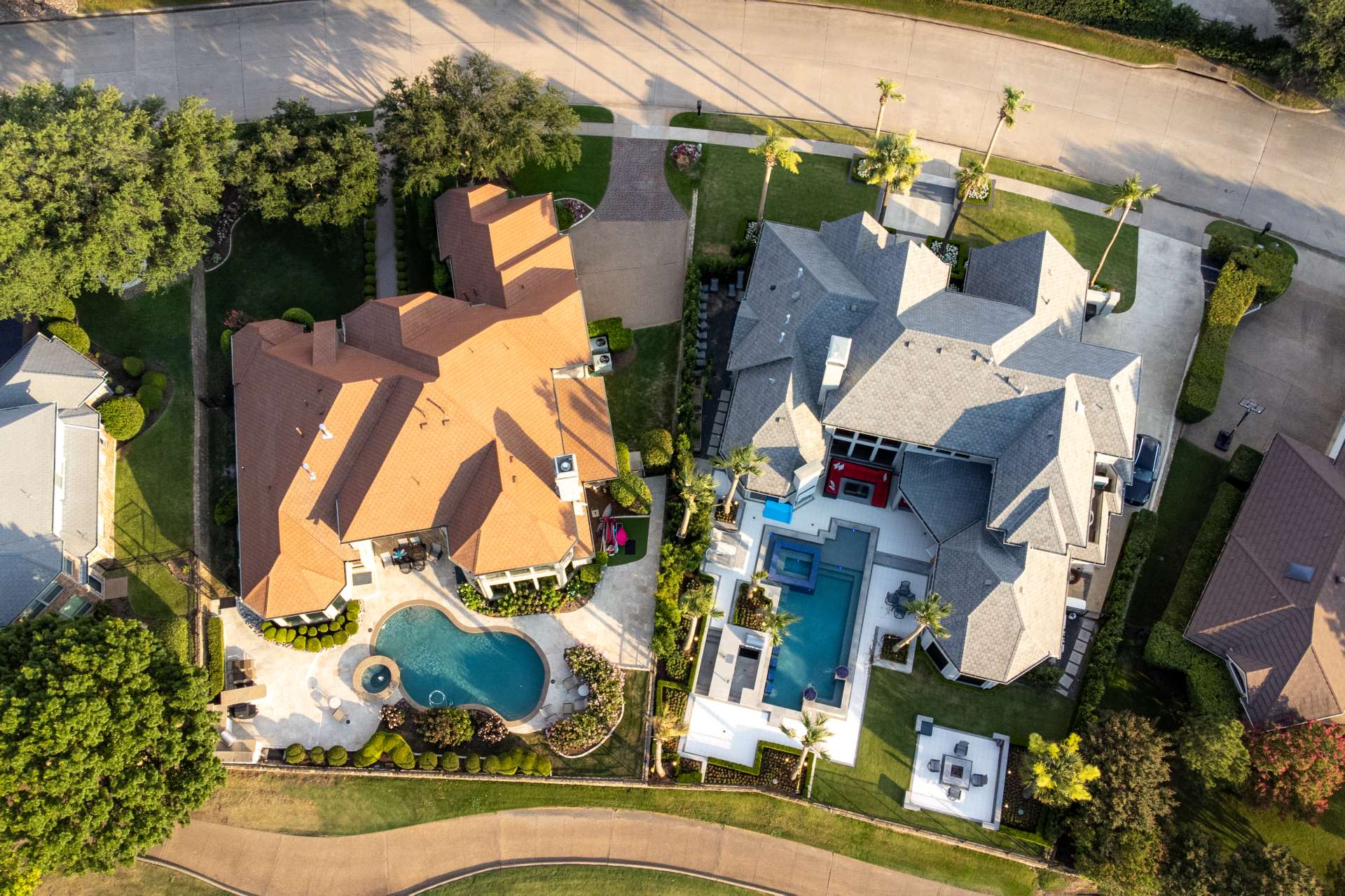 Aerial view of two luxury homes with swimming pools, captured by a drone, showing detailed landscaping, architecture, and outdoor living spaces — highlighting why drone photography is essential for real estate marketing.