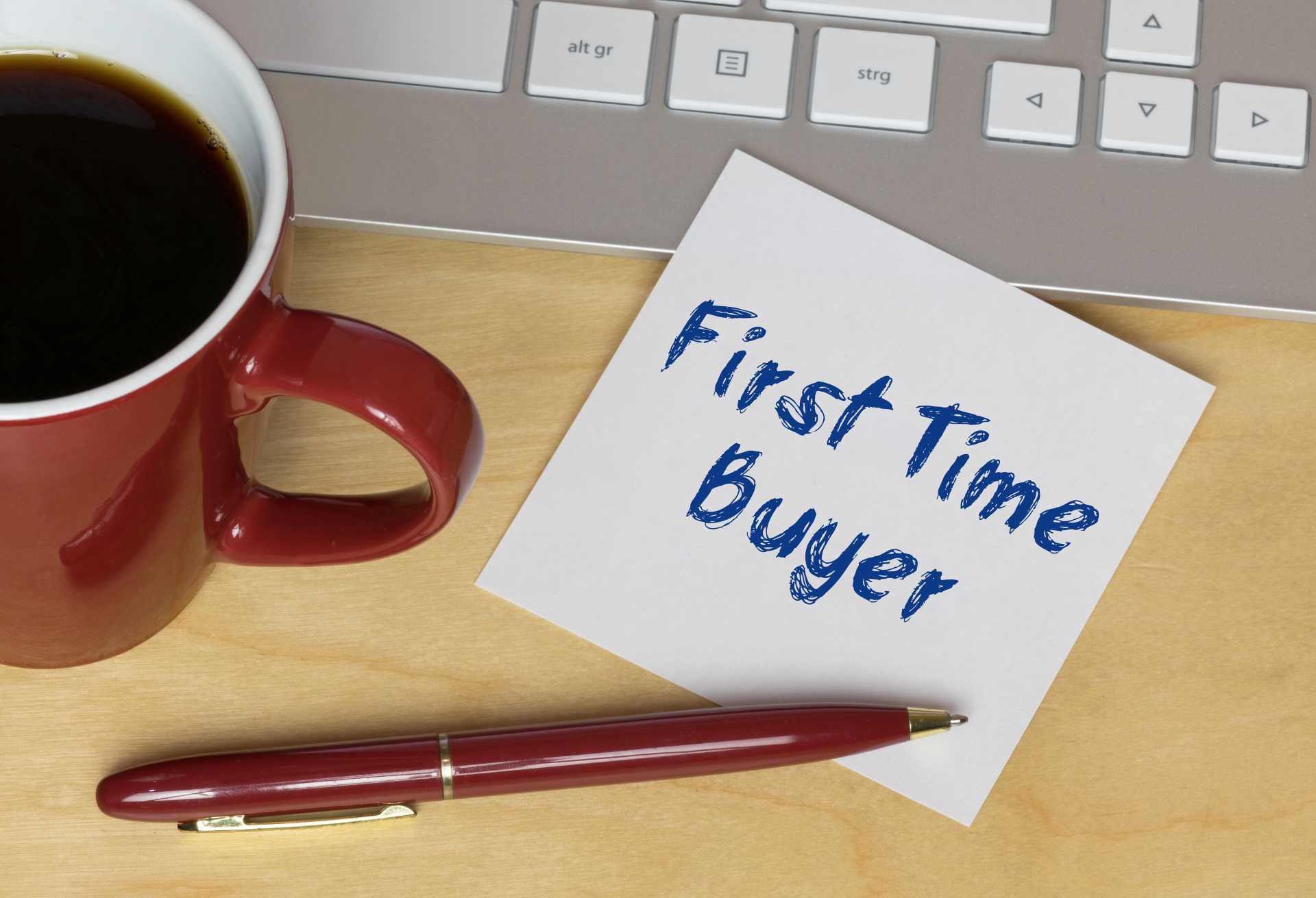Breaking the Homeownership Barrier – First Time Buyer concept with coffee cup, pen, and note on desk symbolizing guidance and tips for new homeowners.