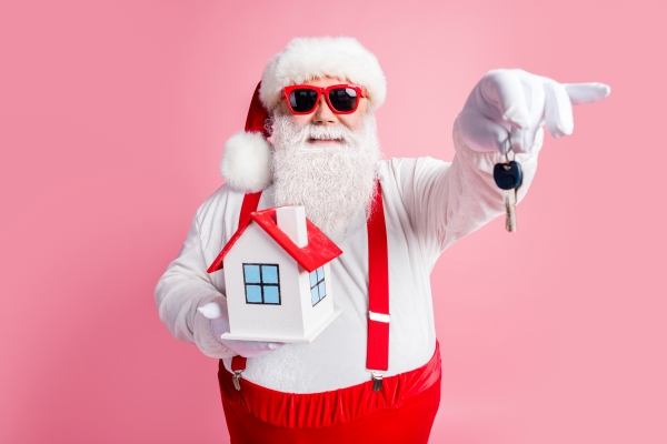 Santa holding house keys and model home — holiday home sales in Dallas, texas