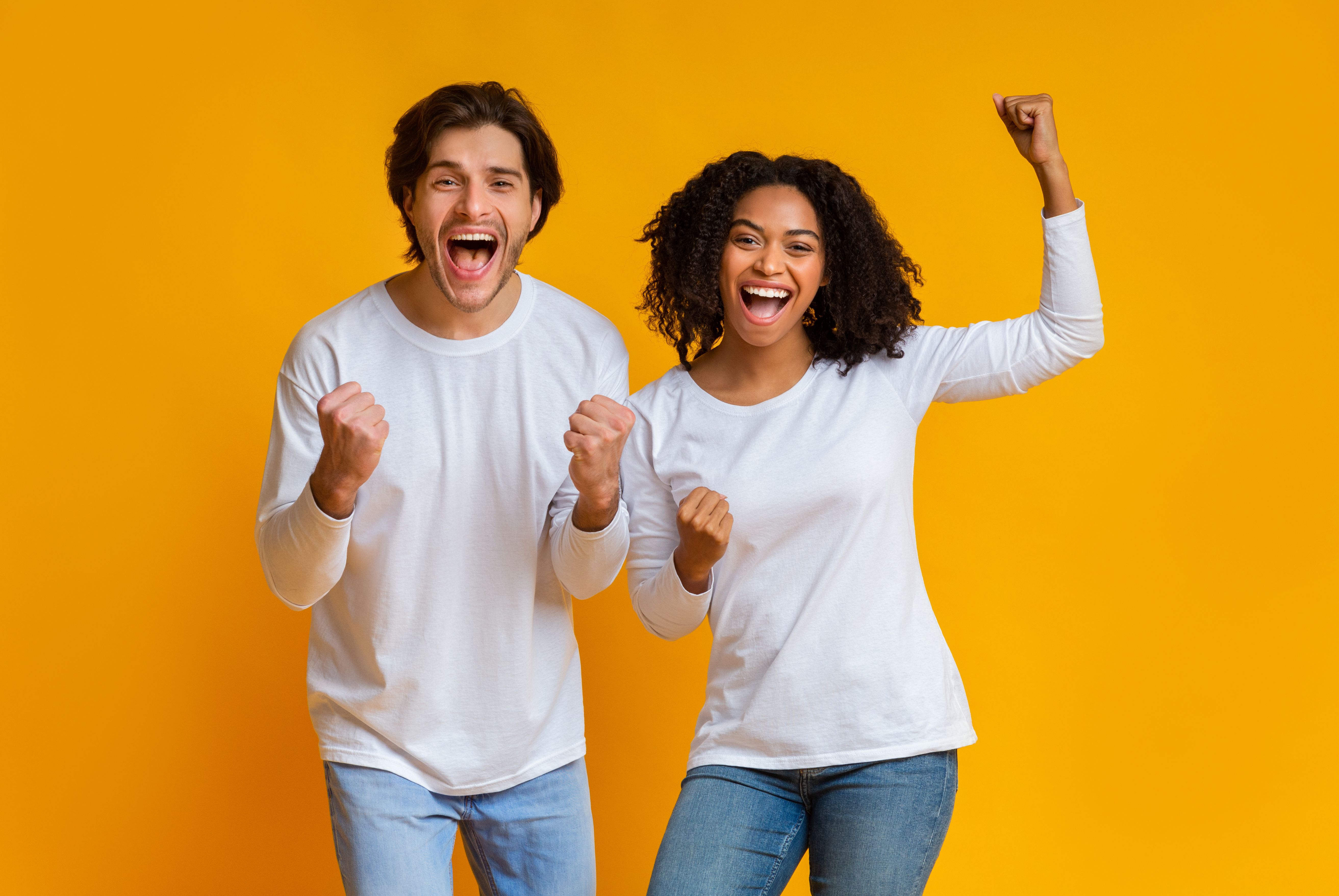 Excited couple celebrating a successful home purchase, showing Dallas home buyers winning in today's luxury market.