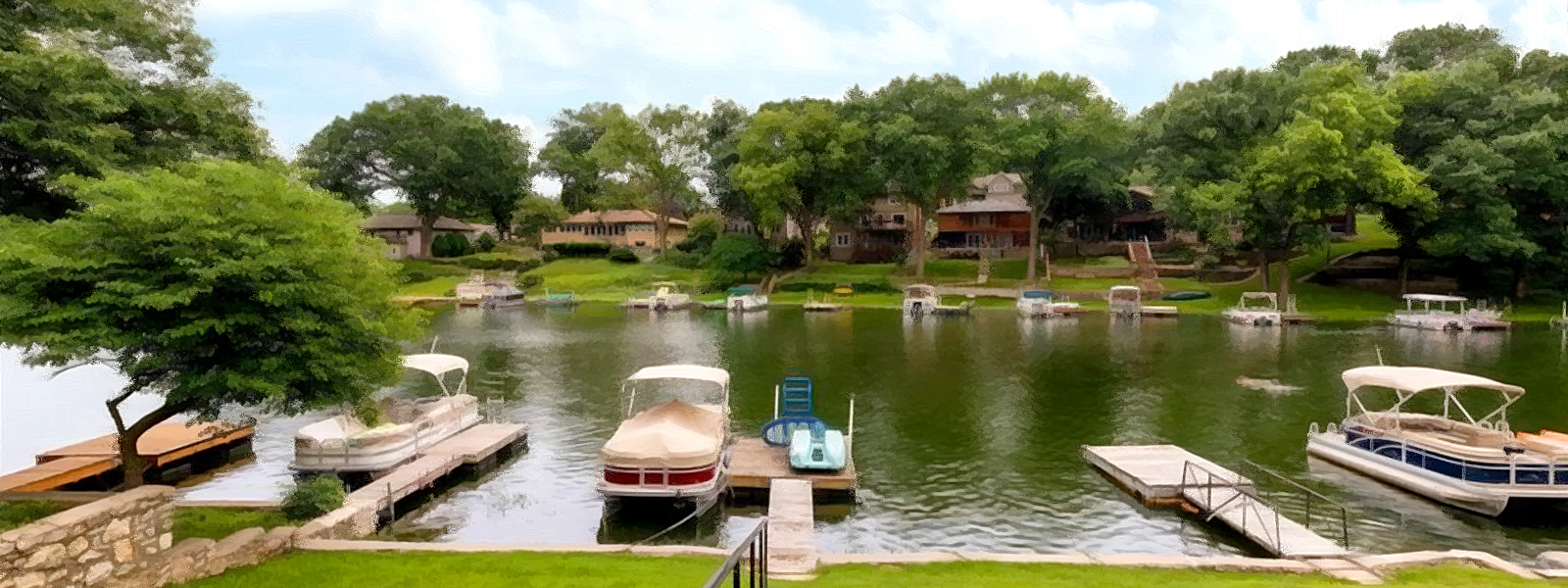 A view of the water, homes, and boats a Lake Waukomis in the Kansas City metro area