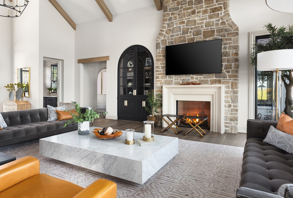 A picture of a living room with sofa couch near a fireplace