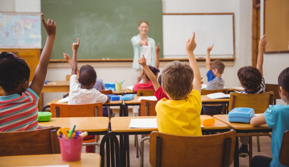 kids raising hands at school