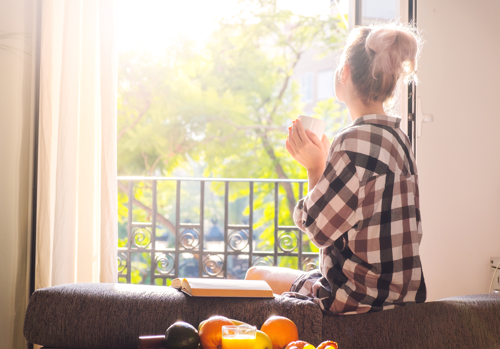 woman enjoying sunlight in her window