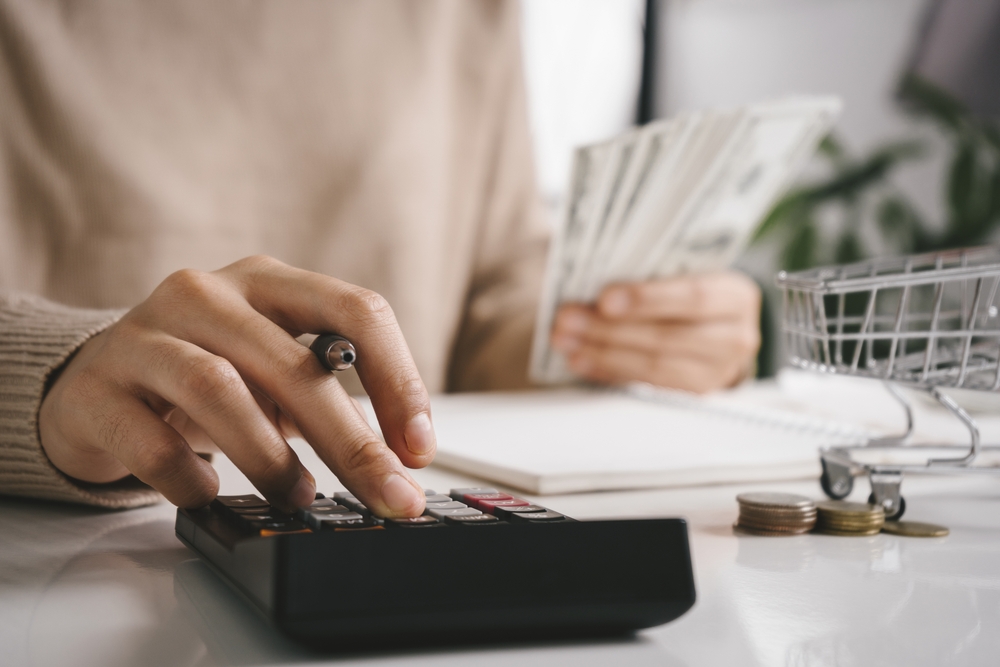 woman with pen and calculator computing