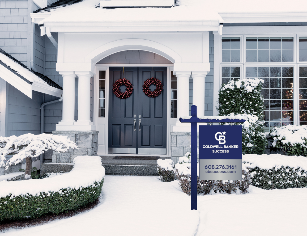 home covered in snow with sale sign