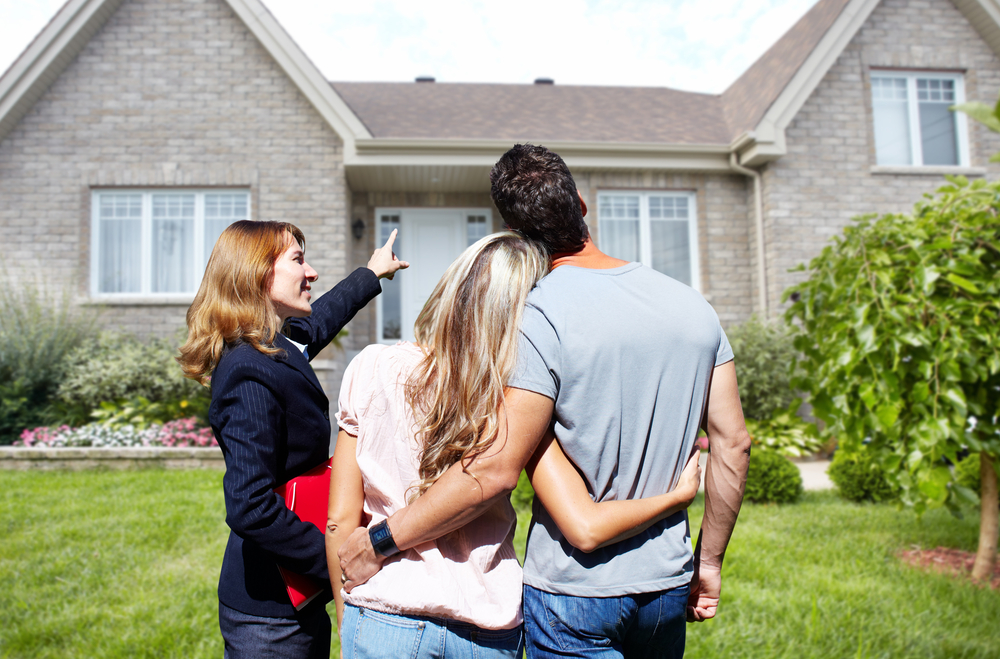 couple looking at a house with a real estate agent