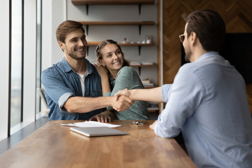 couple handshaking with a real estate expert