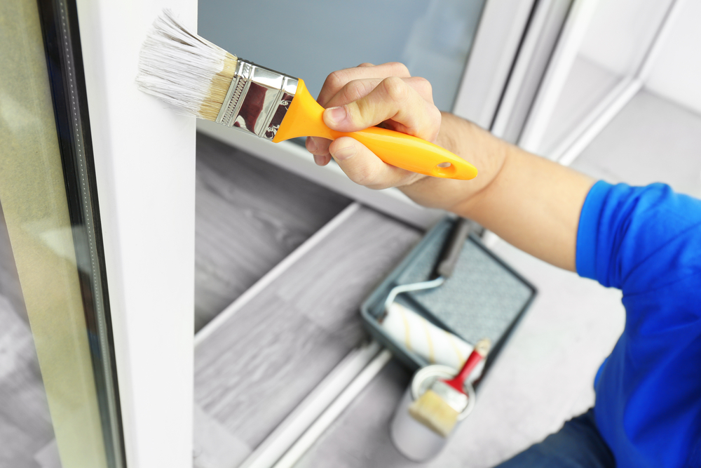 man with paint brush and paint roller