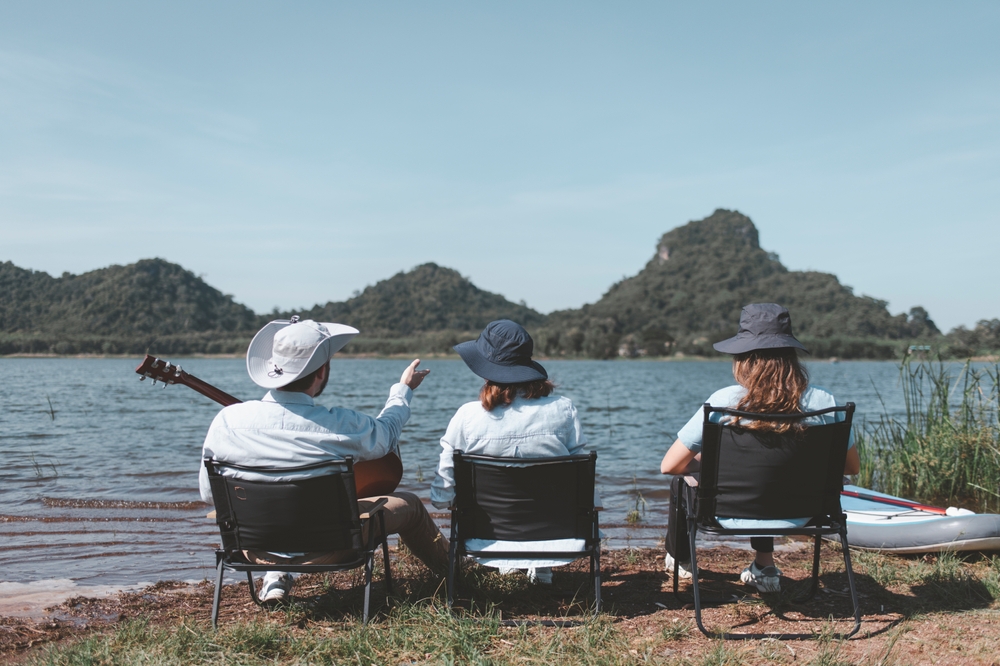family sitting in front of the lake