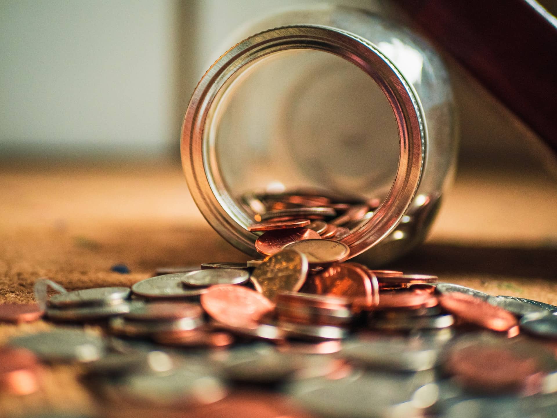 A jar of coins spilling out for costs to prepare before selling your home