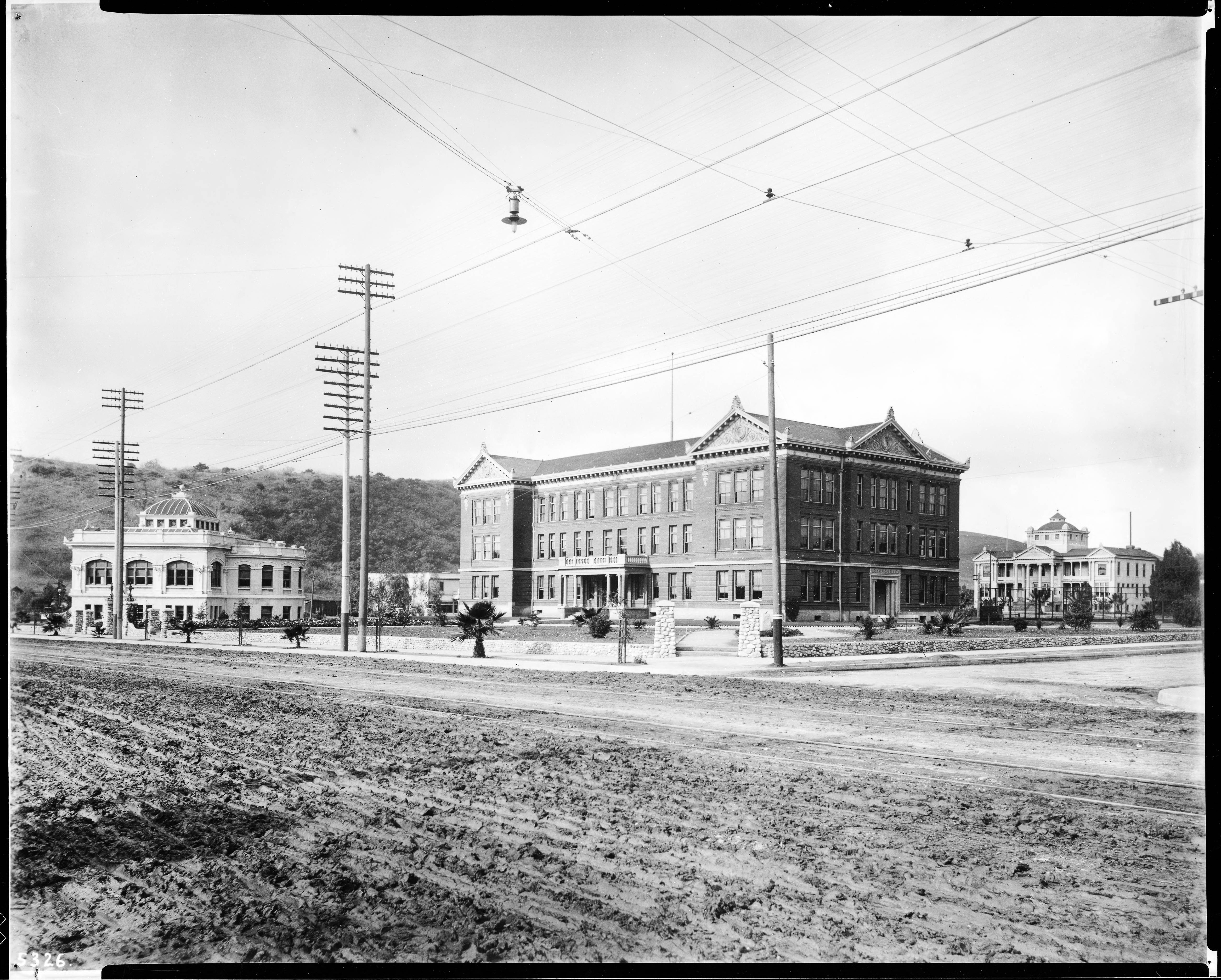 Black-and-white historic photograph of the Occidental College campus in Highland Park around 1908, with large academic buildings, utility poles and open land.
