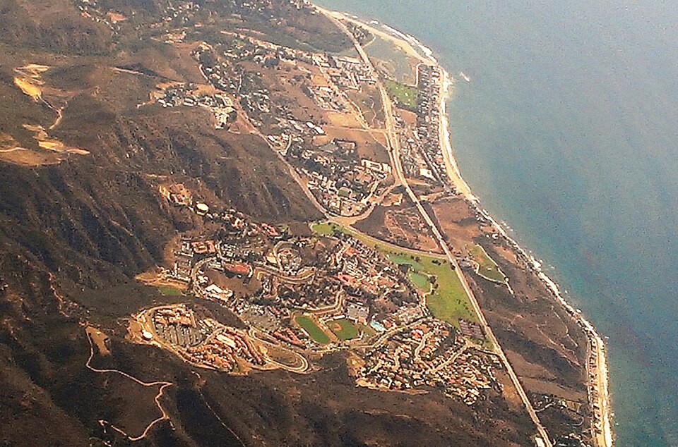 Malibu’s geography is beautiful, but its hillsides, coastline, and limited buildable land make development more complicated than it appears. Aerial view of Malibu’s coastline near Pepperdine University, showing hills, campus buildings, roads, beaches, and the Pacific Ocean.
