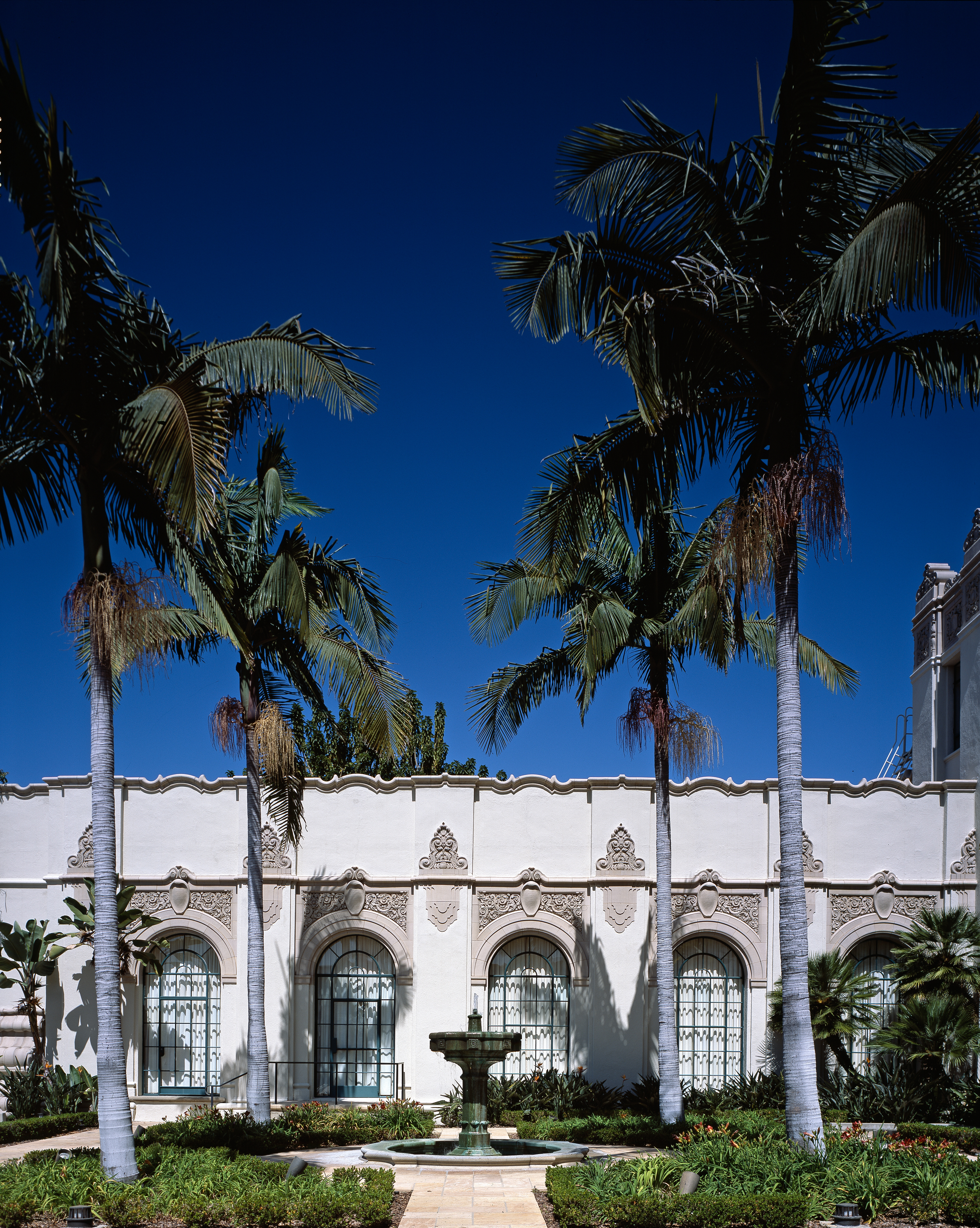 Beverly Hills City Hall with Spanish Revival architecture, palm trees and a clear sky.