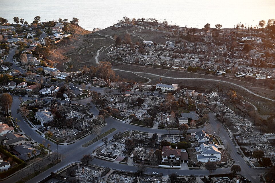 The 2025 Palisades Fire reshaped one of Los Angeles’ most desirable coastal communities. Aerial view of fire-damaged homes and lots in Pacific Palisades after the 2025 Palisades Fire, with the Pacific Ocean in the background.