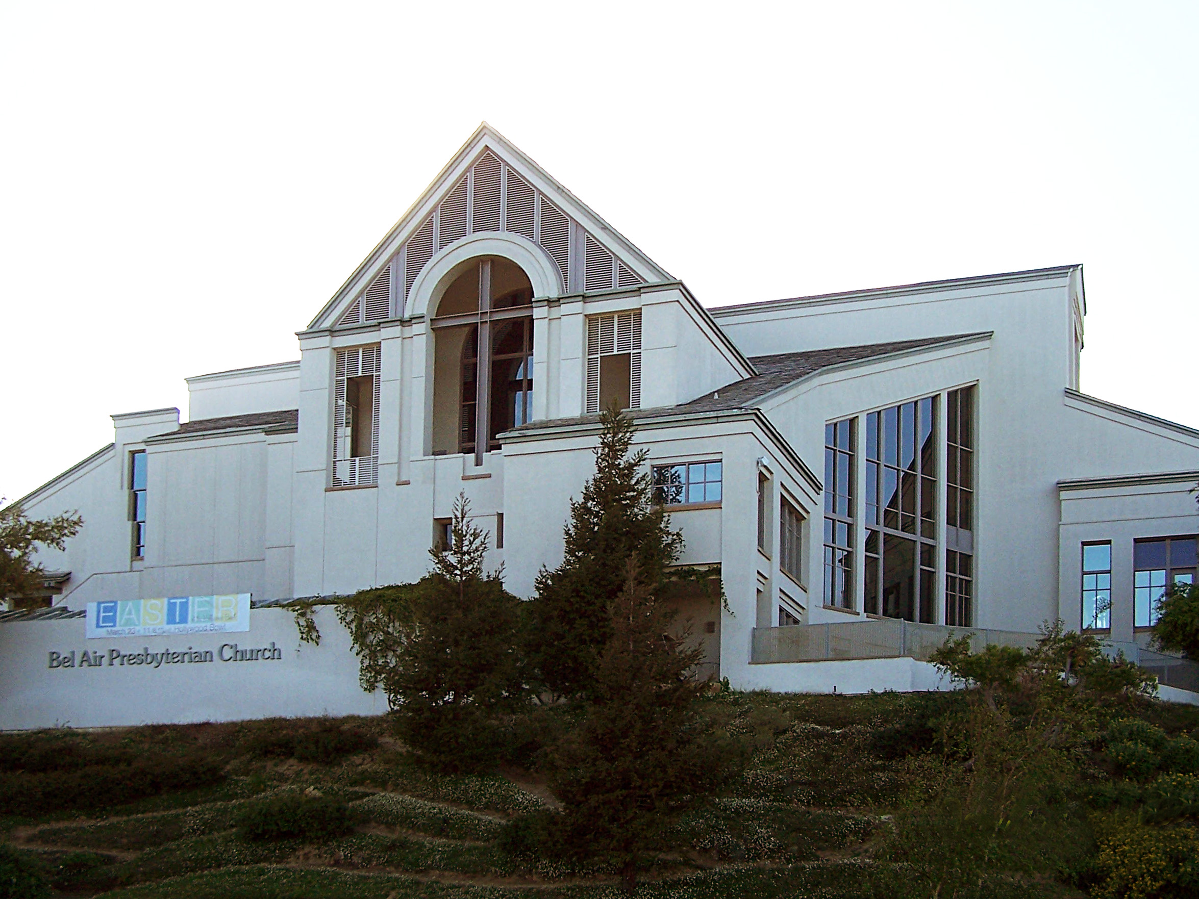 Bel Air Presbyterian Church on a hillside, with a large white building, steep rooflines, tall windows and landscaping.