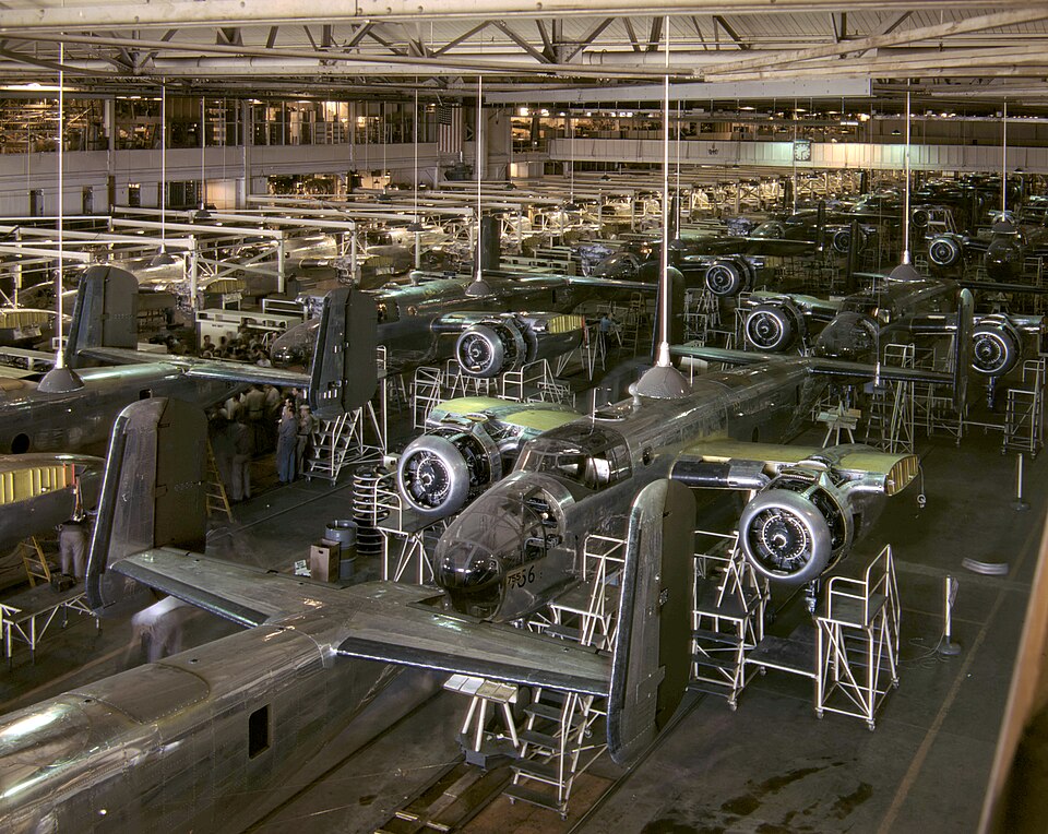 North American Aviation production in Inglewood during the World War II era. Color photograph of B-25 bomber aircraft being assembled inside the North American Aviation plant in Inglewood, with rows of unfinished planes and workers on the factory floor.