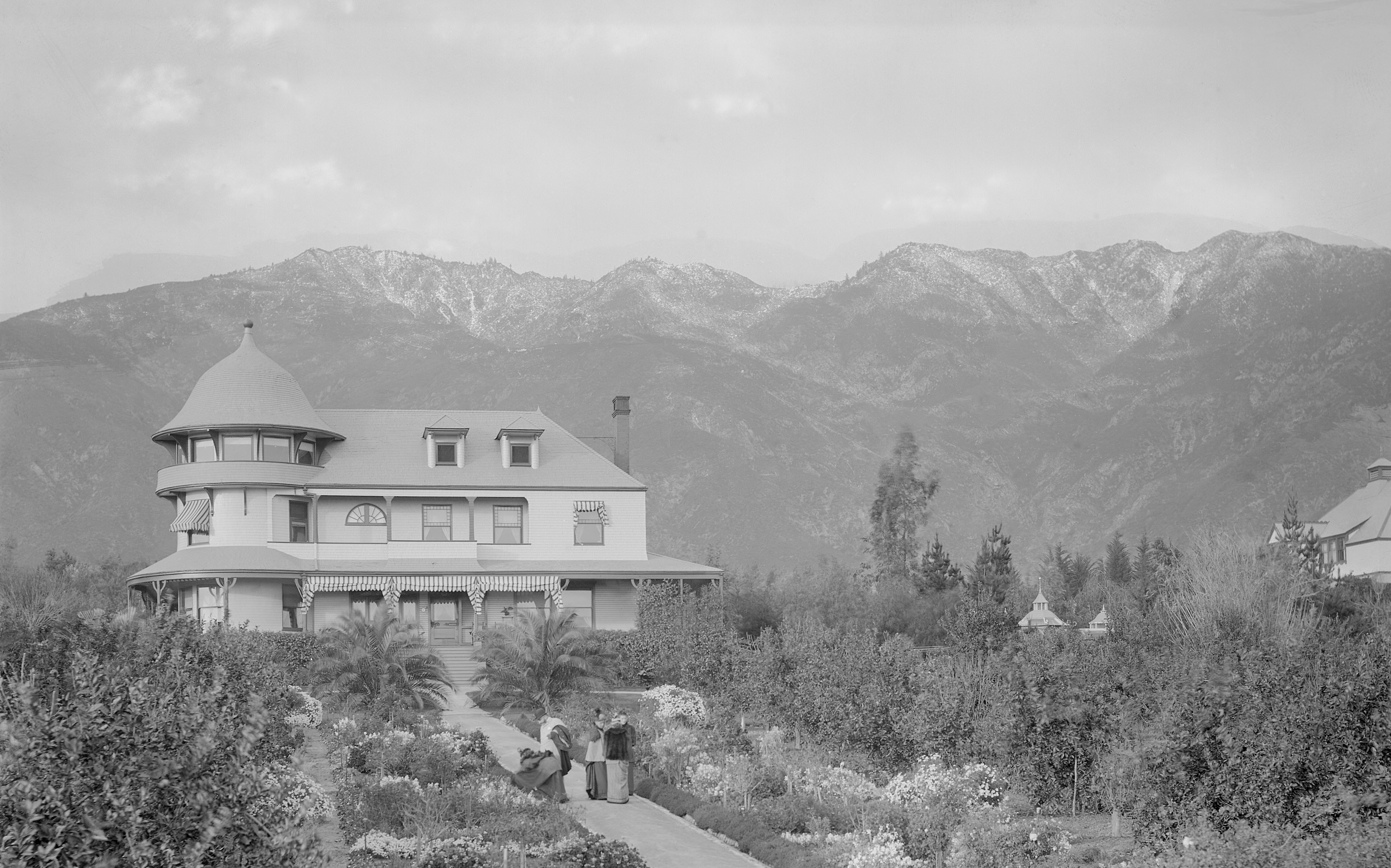 Historic black and white photograph of Andrew McNally’s Altadena residence surrounded by gardens with mountains in the background.