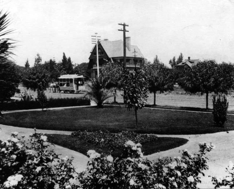 Black-and-white historic photograph of Colorado Street and Oakland Avenue in Pasadena around 1890, with a streetcar, homes, trees and gardens.