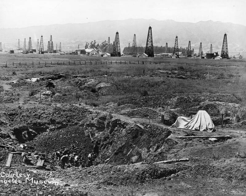 Before Hancock Park became a luxury neighborhood, the surrounding Rancho La Brea land was deeply tied to oil production. Historic black-and-white image of oil derricks on the former Rancho La Brea land in Los Angeles.