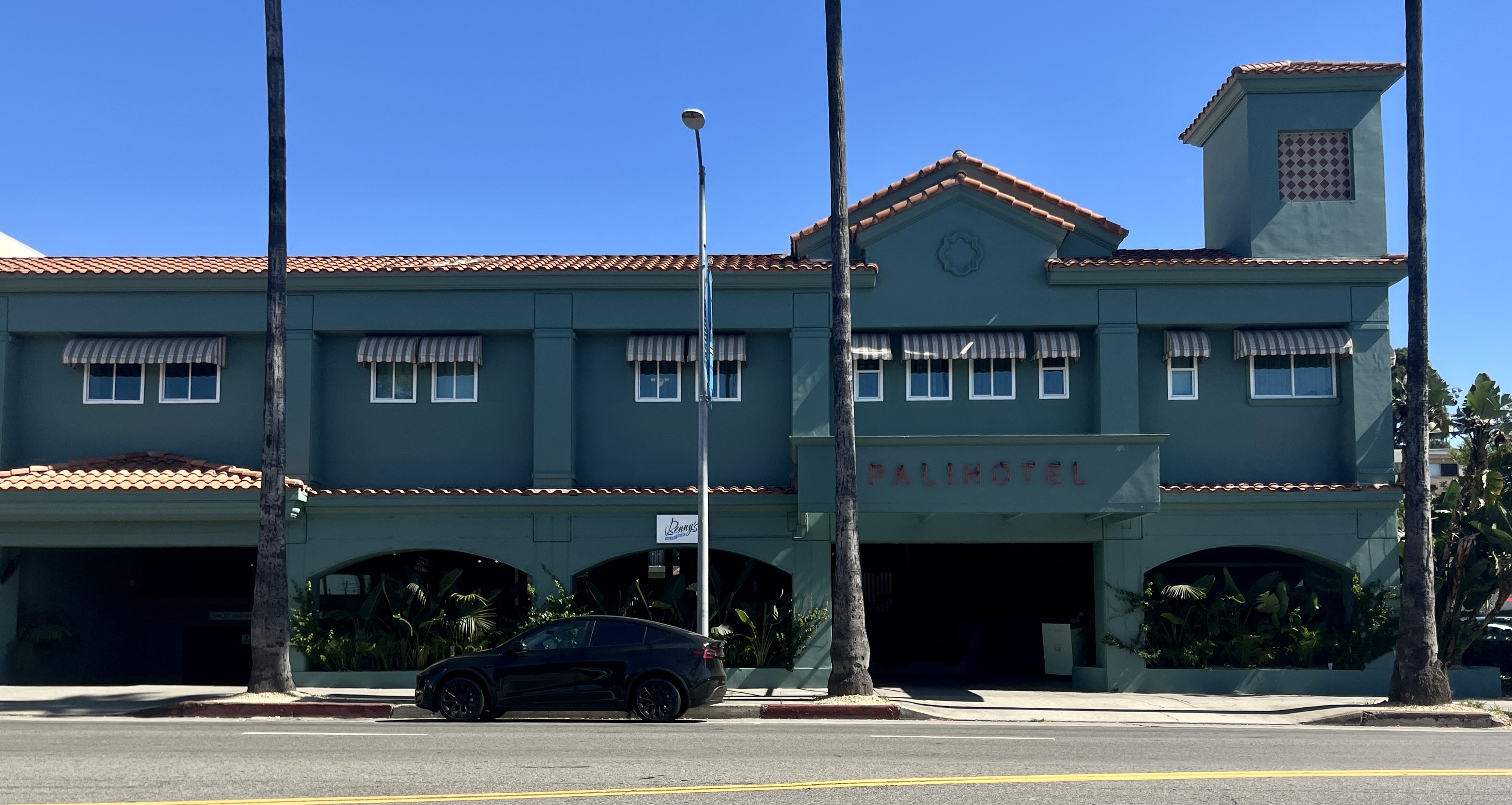 The Bird Streets sit above the Sunset Strip, where LA nightlife and celebrity culture helped shape the value of the hills behind it. Sunset Boulevard hotel facade below the Hollywood Hills and Bird Streets area.