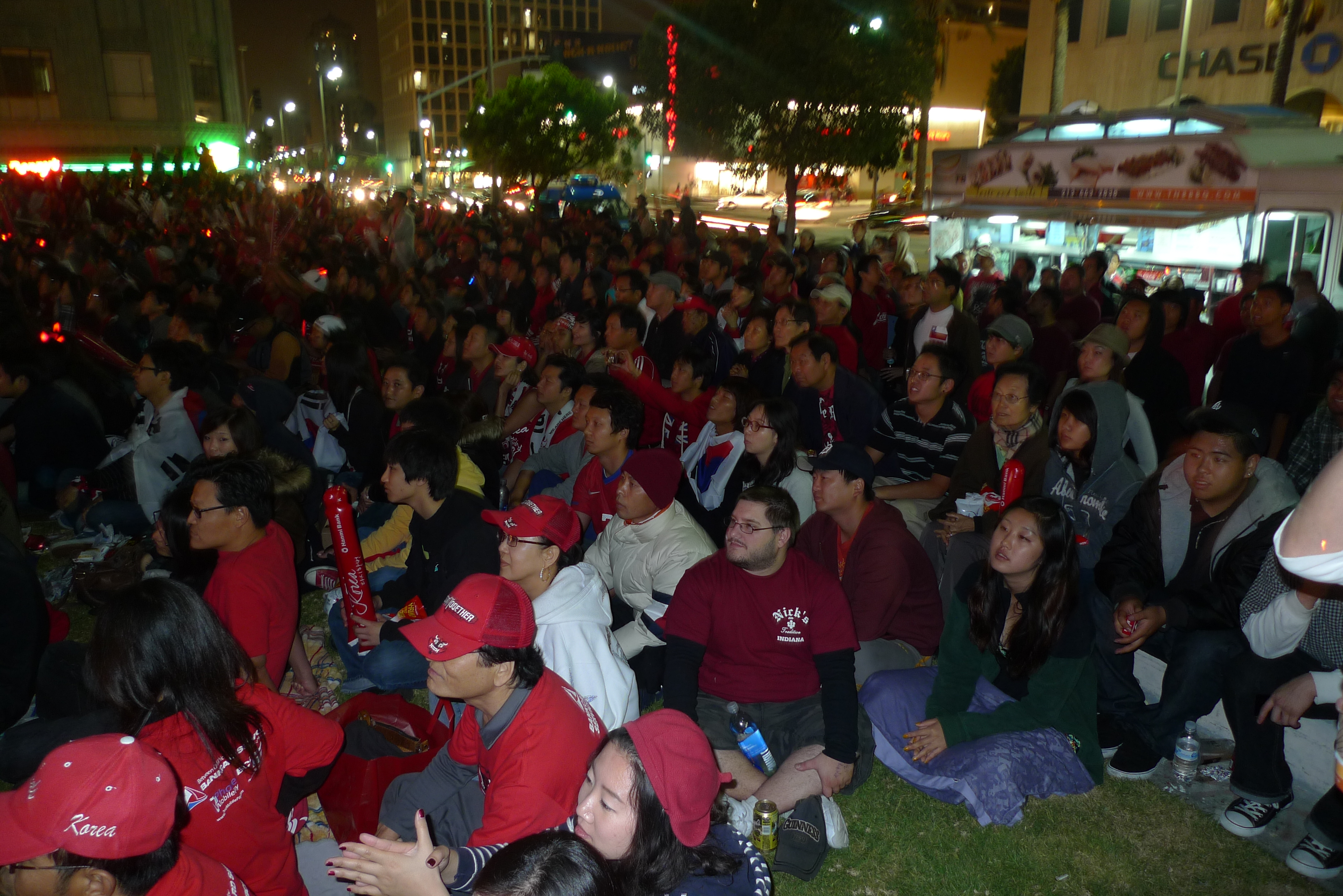 Large crowd gathered outdoors in Koreatown at night during a 2010 World Cup celebration.