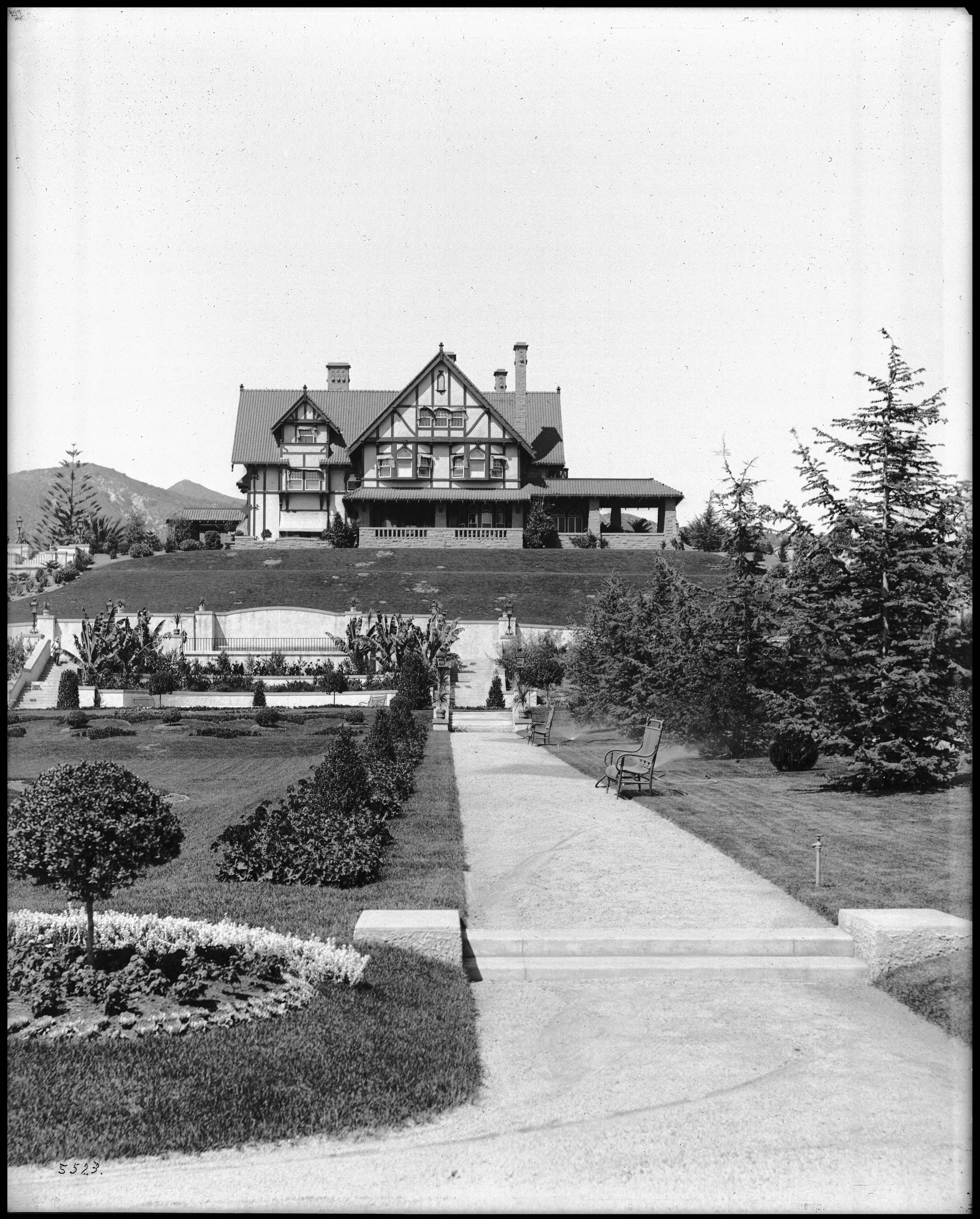 Historic Arthur Letts Holmby House with formal gardens and mountain backdrop.