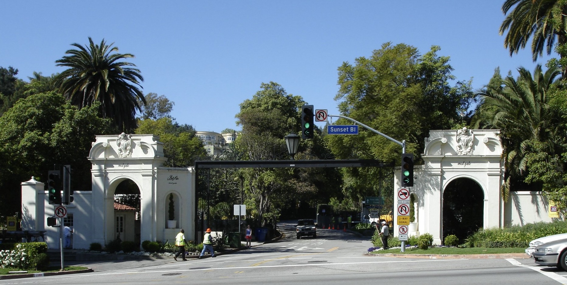 Historic Bel Air west gate entrance with palm trees and road leading into the neighborhood.