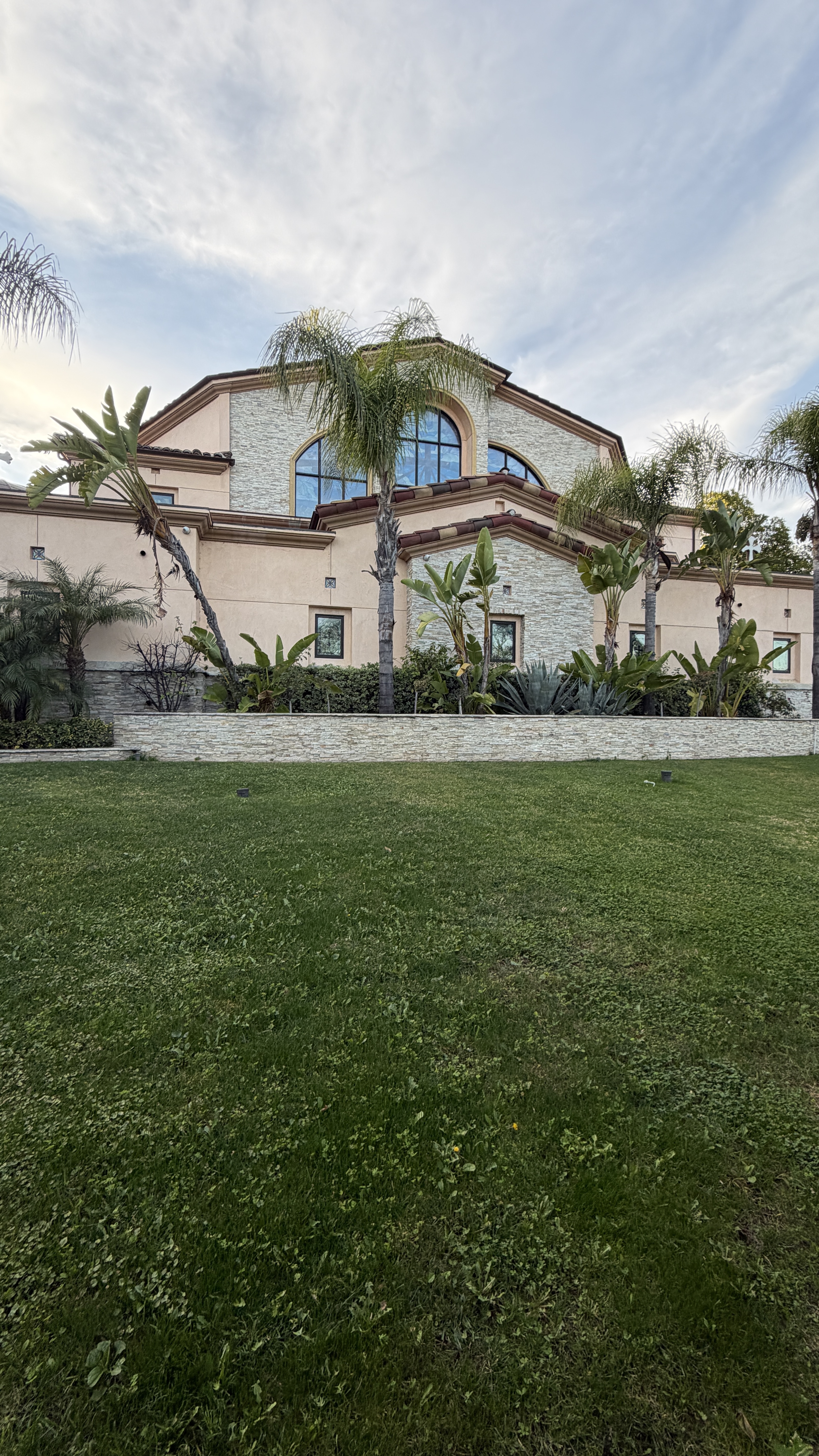 Tarzana residential estates and religious landmarks. A large church building in Tarzana with palm trees, arched windows and landscaped grounds.
