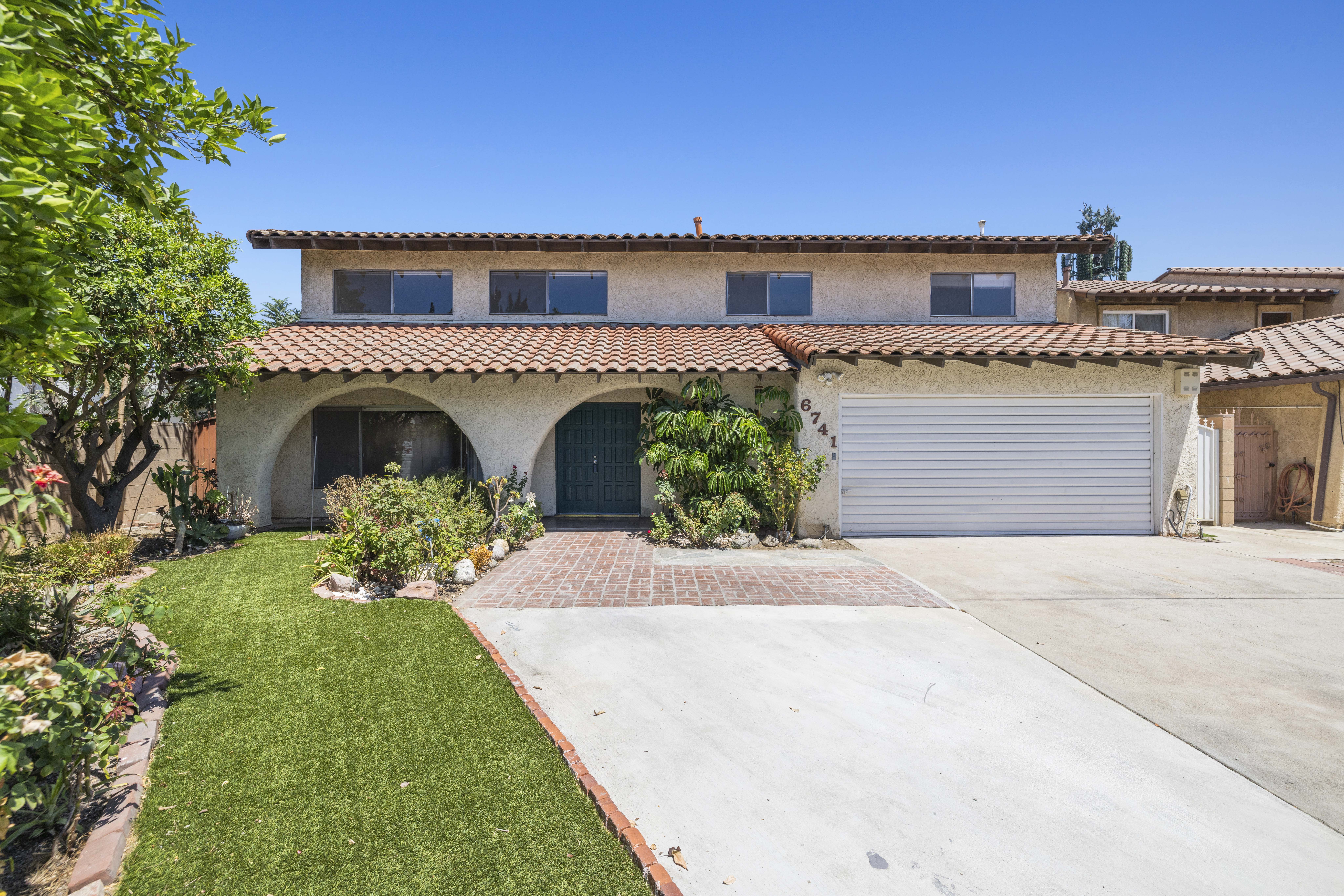 Spanish-style two-story home at 6741 Buffalo Avenue in Valley Glen featuring a red tile roof, white stucco exterior, and arched front entry on a quiet cul-de-sac.