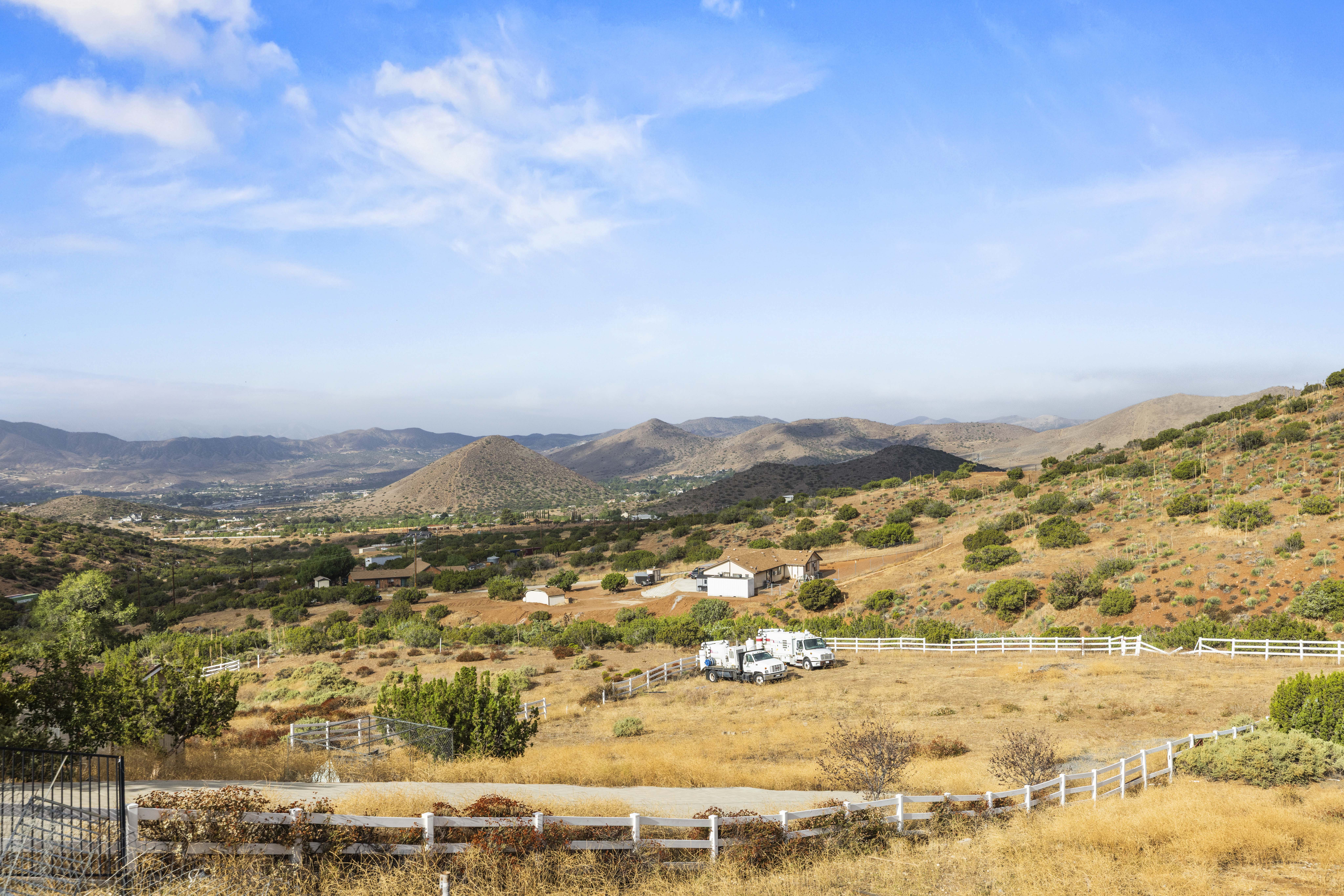 Mountain views from 34665 Desert Rd, Acton CA, showing the fully fenced 1.5-acre lot. A-2-2 Heavy Agricultural zoning, 4 bedrooms, 3 bathrooms, 2,625 sq ft. Listed at $1,075,000 by The Kathy Watterson Team at RE/MAX of Santa Clarita.