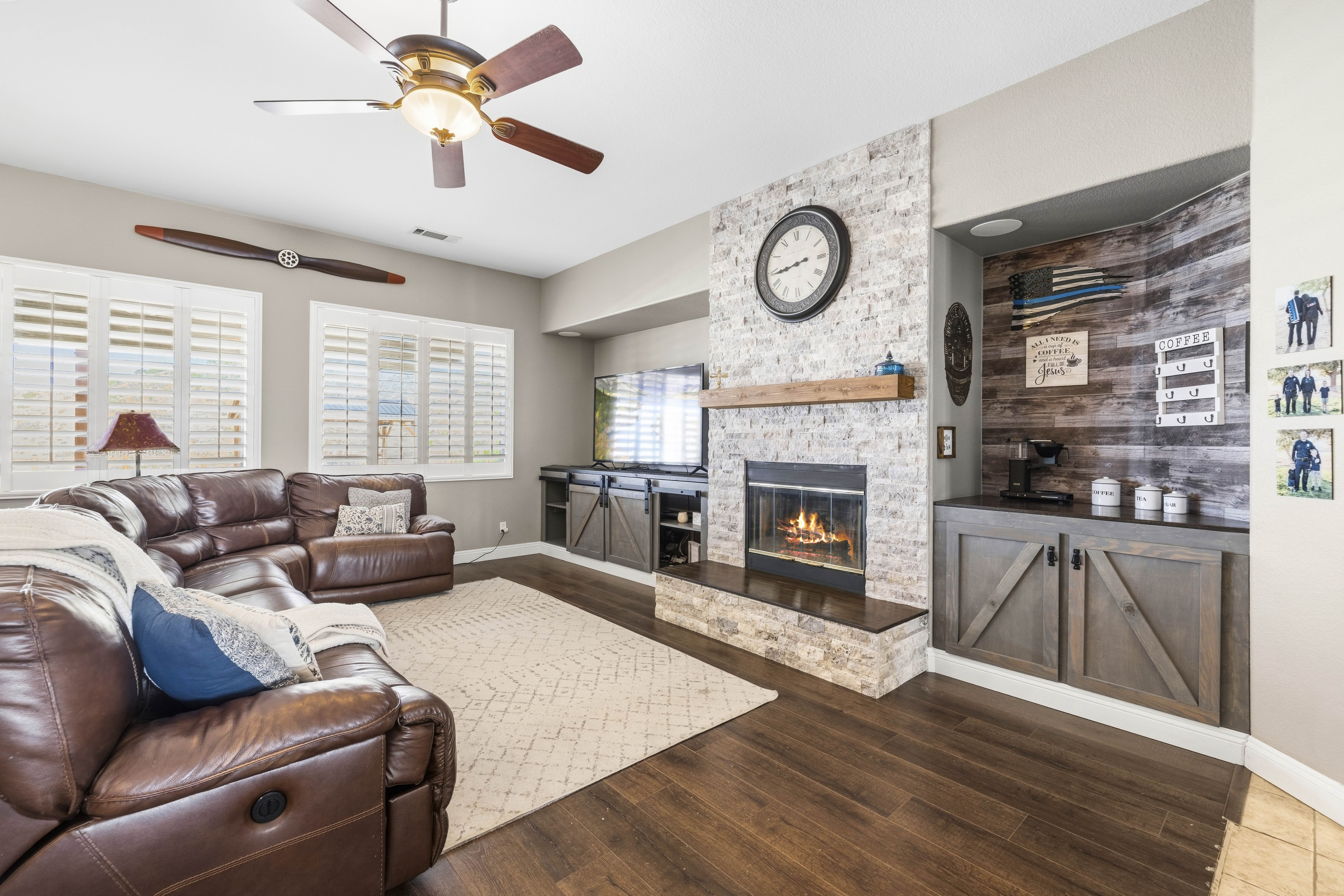Family room with stacked stone fireplace and custom built-ins at 34665 Desert Rd, Acton CA. 4-bedroom, 3-bathroom home listed at $1,075,000 by The Kathy Watterson Team at RE/MAX of Santa Clarita.