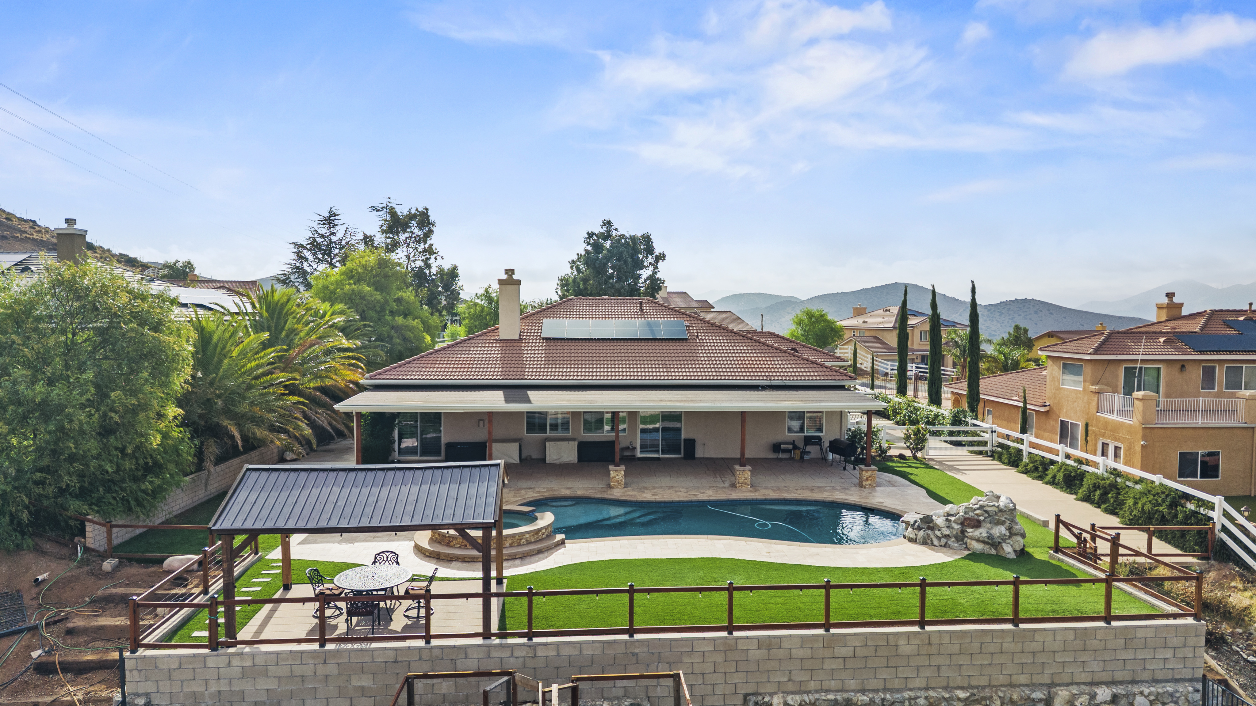 **Alt text:** Aerial view of pool, spa, covered patio, and gazebo at 34665 Desert Rd, Acton CA, a 4-bedroom home on 1.5 fully fenced acres with mountain views. Listed at $1,075,000 by The Kathy Watterson Team at RE/MAX of Santa Clarita.