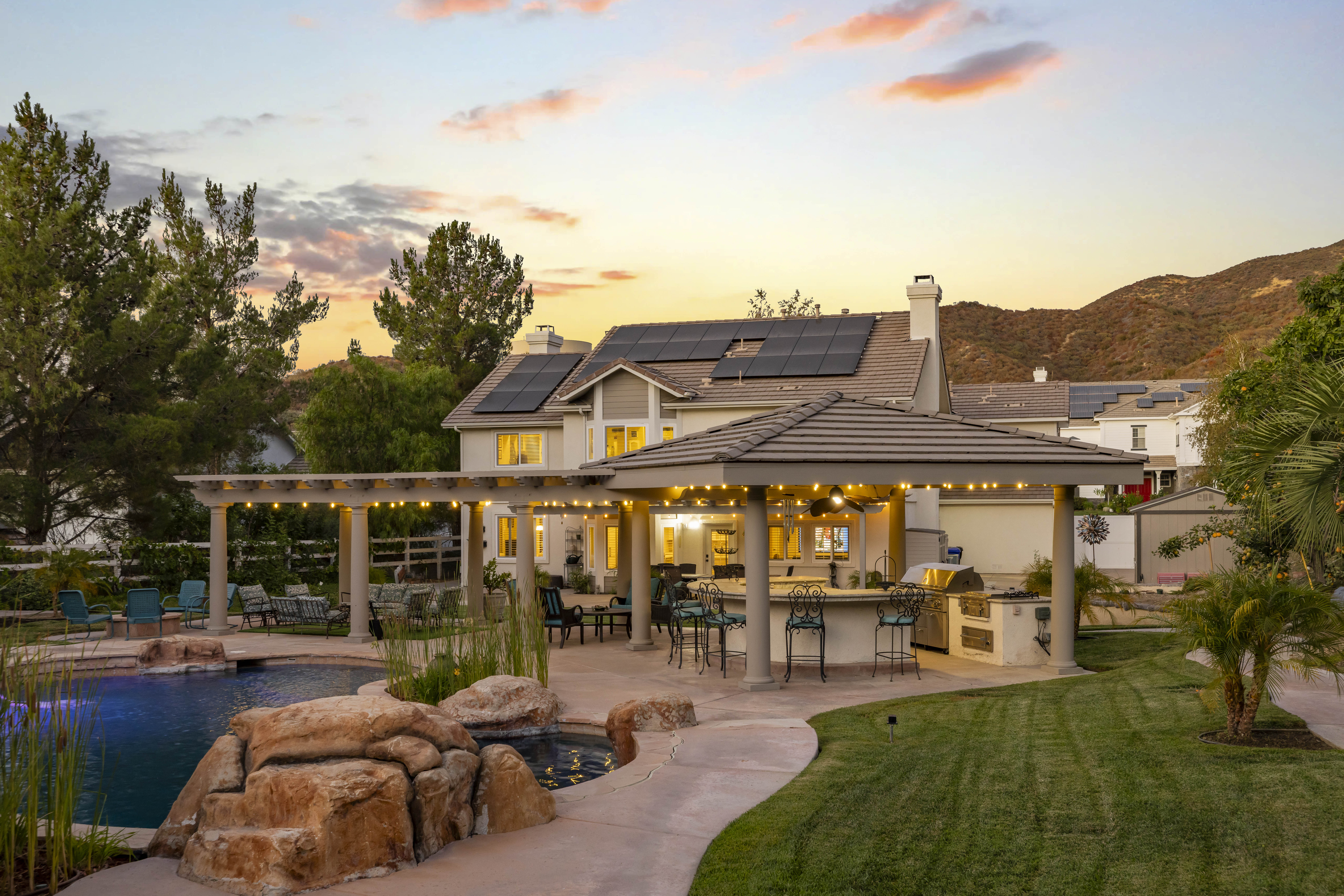 Outdoor kitchen and pool bar with 48-inch grill, dual refrigerators, granite countertops, and horseshoe-shaped seating at 15260 Saddleback Rd, Santa Clarita, CA 91387, in the Ridgecrest tract of Sand Canyon. Sold by The Kathy Watterson Team at RE/MAX of Santa Clarita.