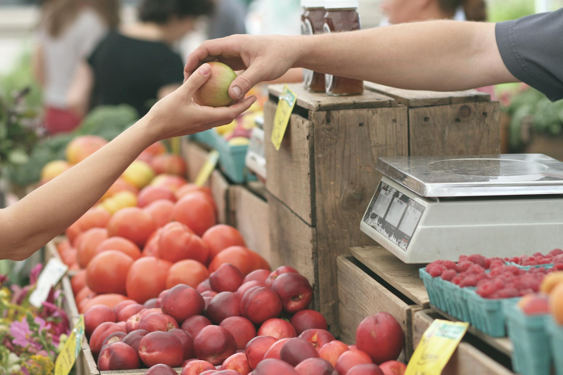 A person buying fruit at a farmer’s market