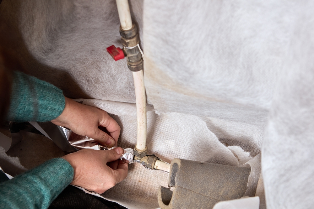  A man installing pipe insulation