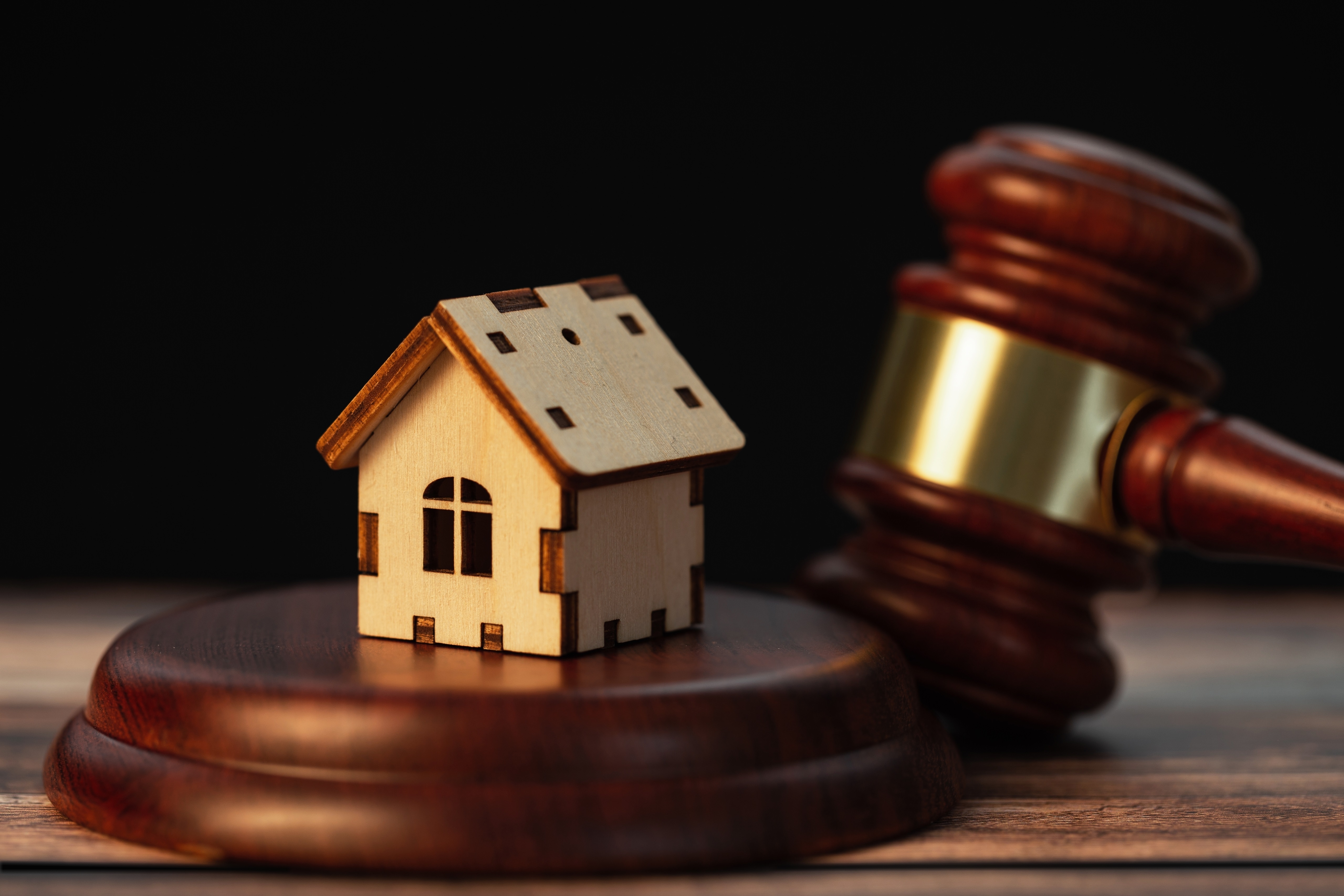 wooden house miniature on top of the sounding block with the gavel